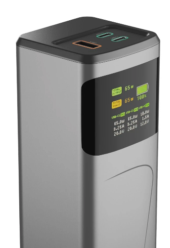 Srebrno-czarny power bank z portami USB. Ma wyświetlacz pokazujący moc wyjściową i procent naładowania baterii. Na górze znajdują się porty ładowania.