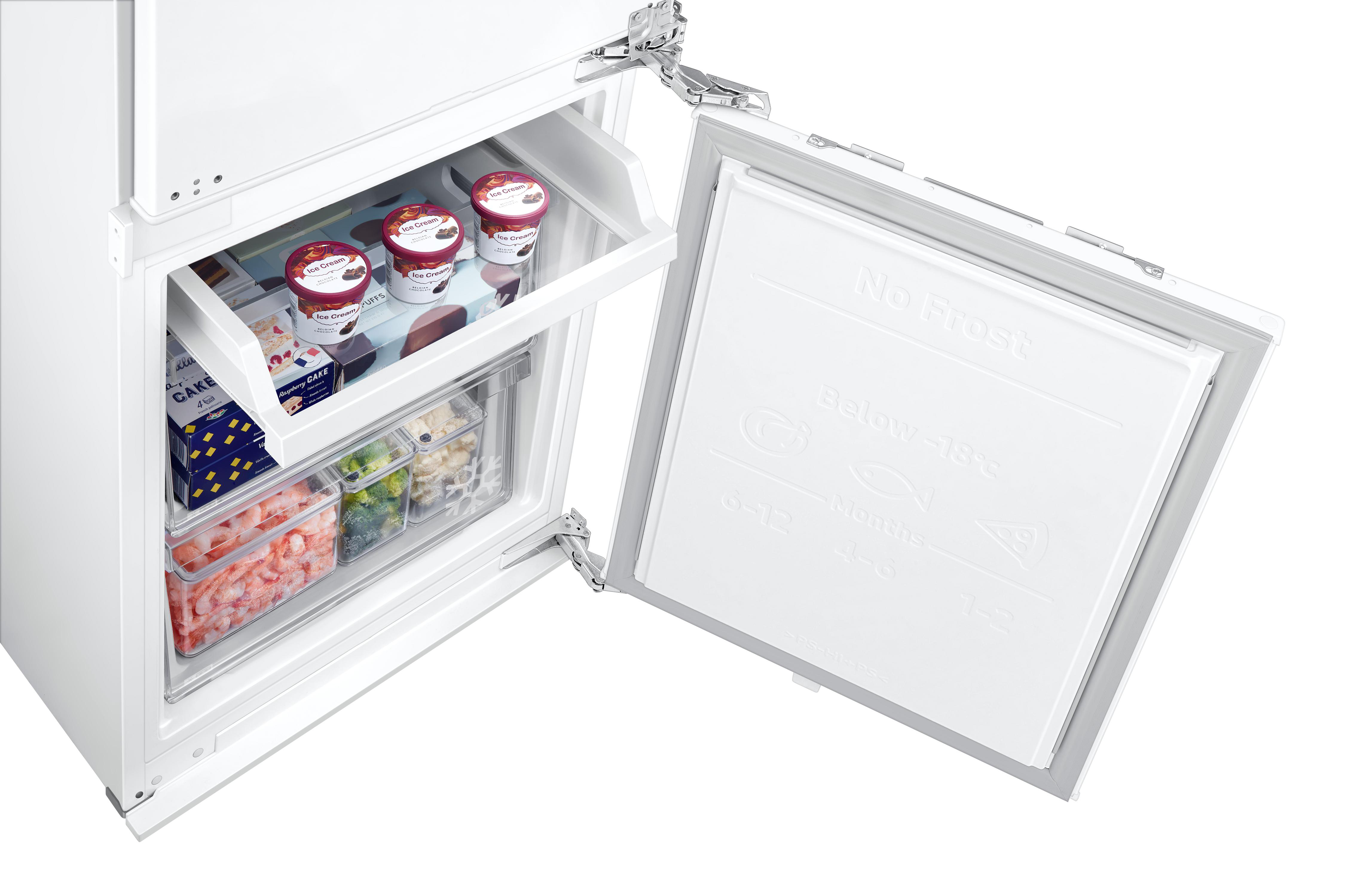 Offener weißer Kühlschrank mit geöffneter Gefriertür. Im Inneren befinden sich Eis, Kuchen, Meeresfrüchte und Gemüse.