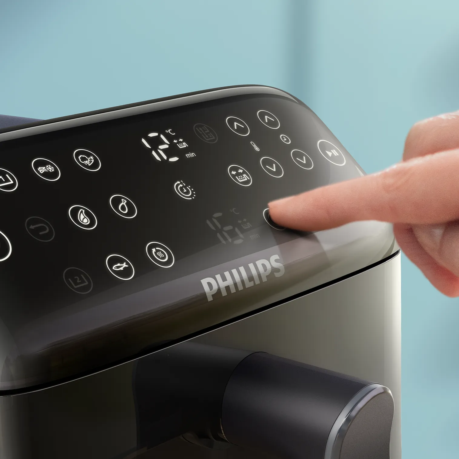 Une main appuie sur un bouton du panneau de commande d'une friteuse Philips. Le panneau affiche des icônes et des chiffres numériques.