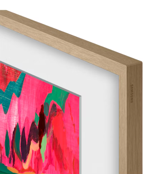 Sztuka abstrakcyjna w drewnianej ramie. Dzieło zawiera różowe i zielone pociągnięcia pędzla. Rama jest jasnobrązowa, widoczne logo Samsung.