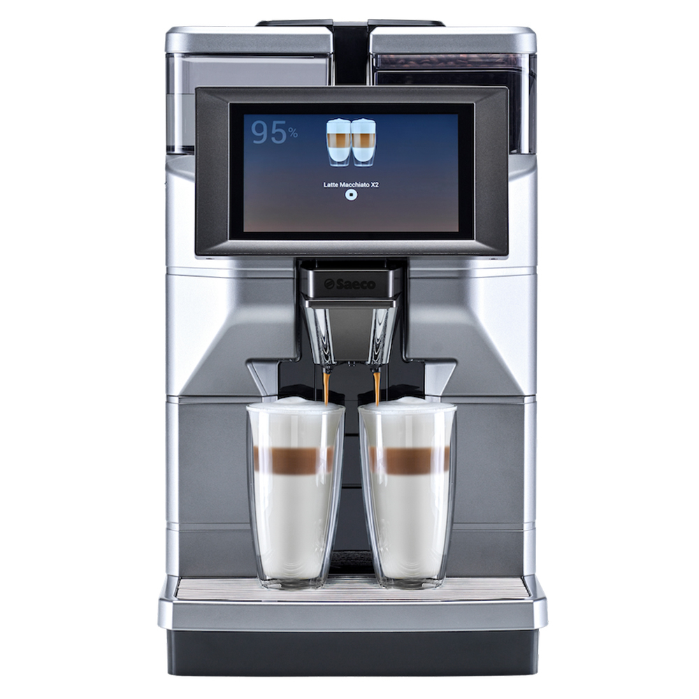 Egy ezüst kávéfőzőgép kávét adagol két réteges pohárba. A képernyőn a latte macchiato elkészítése látható.