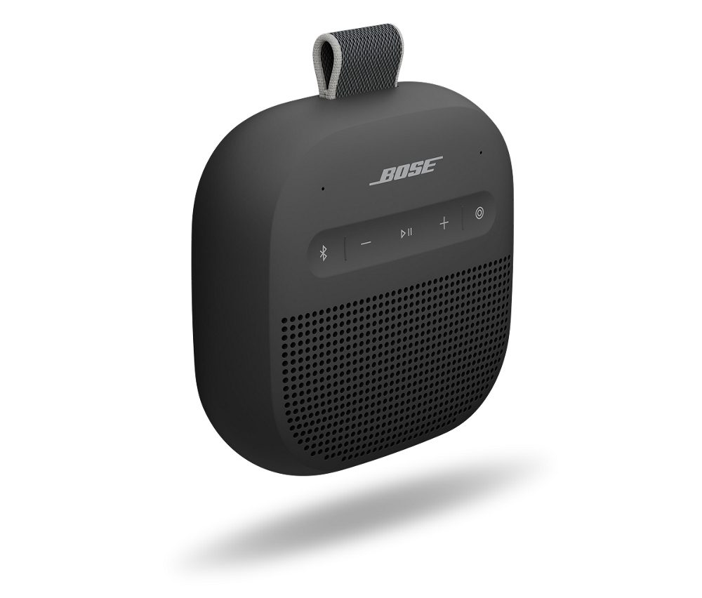 Un altavoz portátil Bose negro con botones de control y un lazo de tela. Se encuentra sobre un fondo blanco.