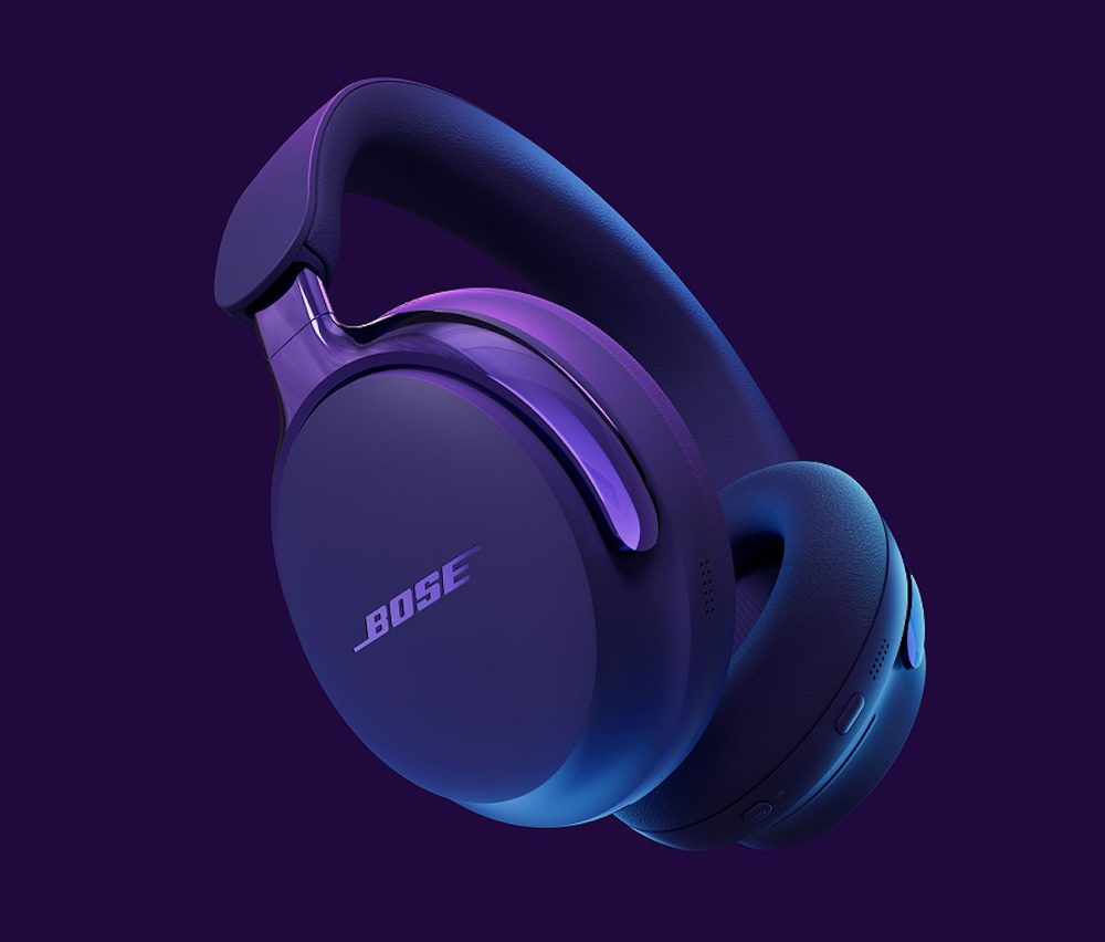 Unos auriculares Bose azul oscuro sobre un fondo morado. Los auriculares están en ángulo, mostrando la marca y los auriculares.