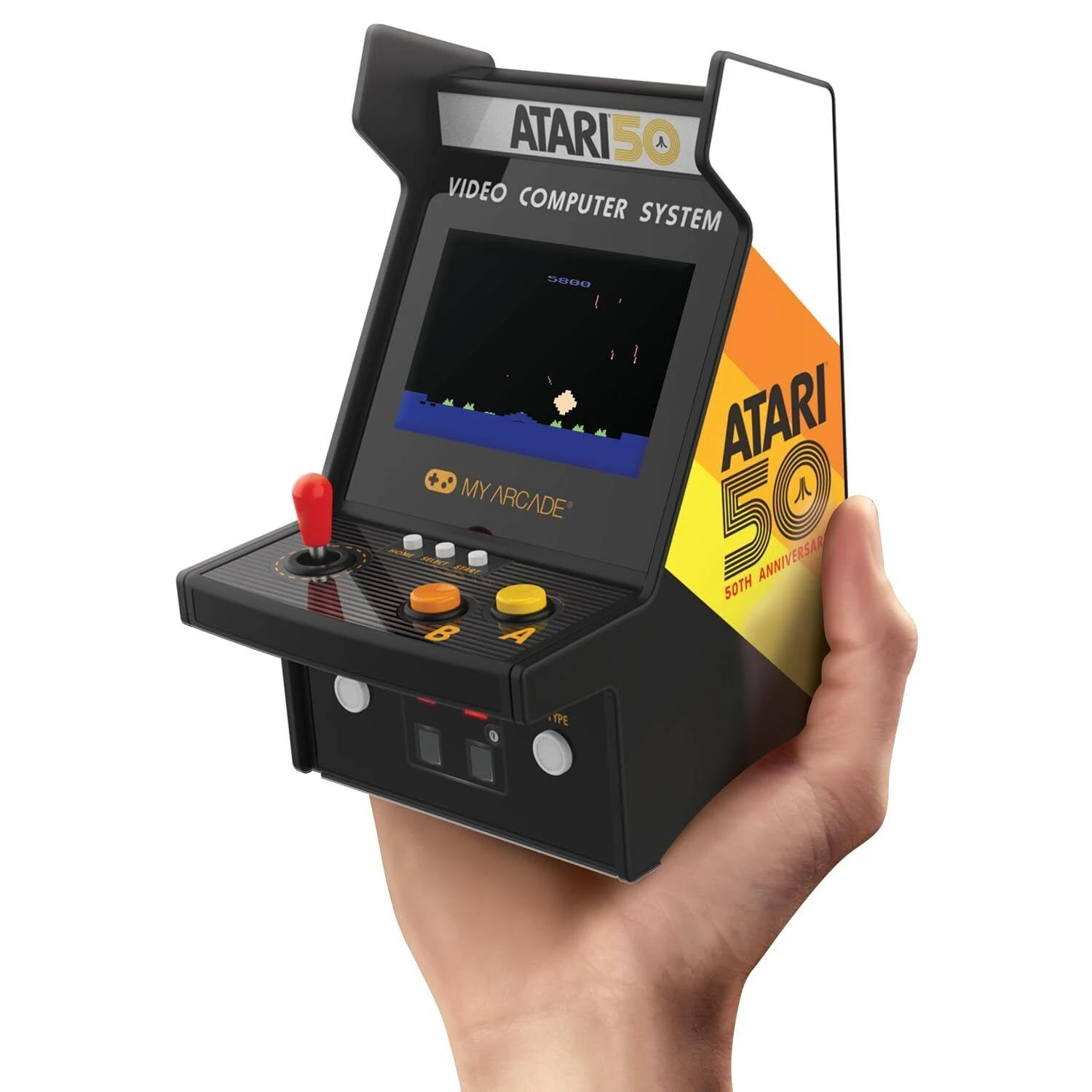 Una persona sostiene una mini arcade Atari. La pantalla muestra un juego, la máquina tiene botones y un joystick. El logo Atari 50 es visible.