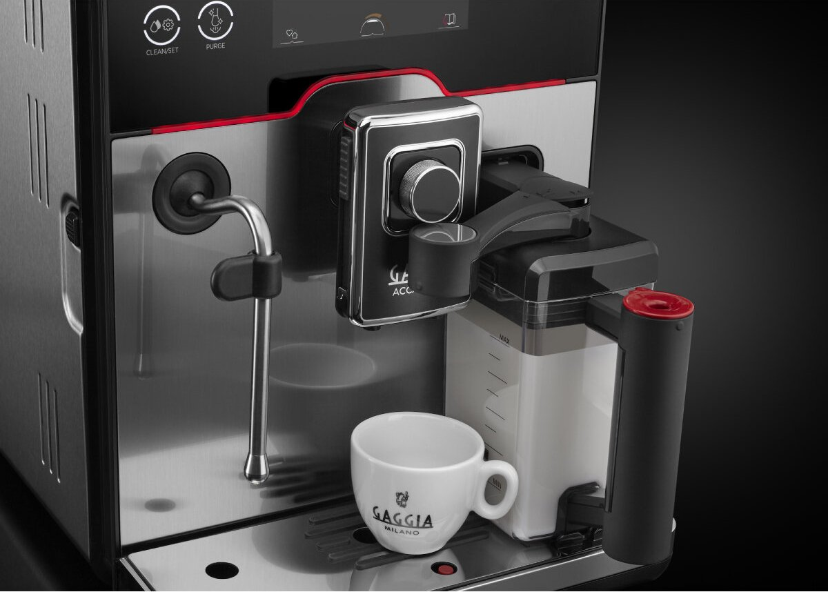Esspresszógép csészével. Fekete-ezüst dizájn. Tejtartály jobbra. Gaggia Milano logó a csészén.
