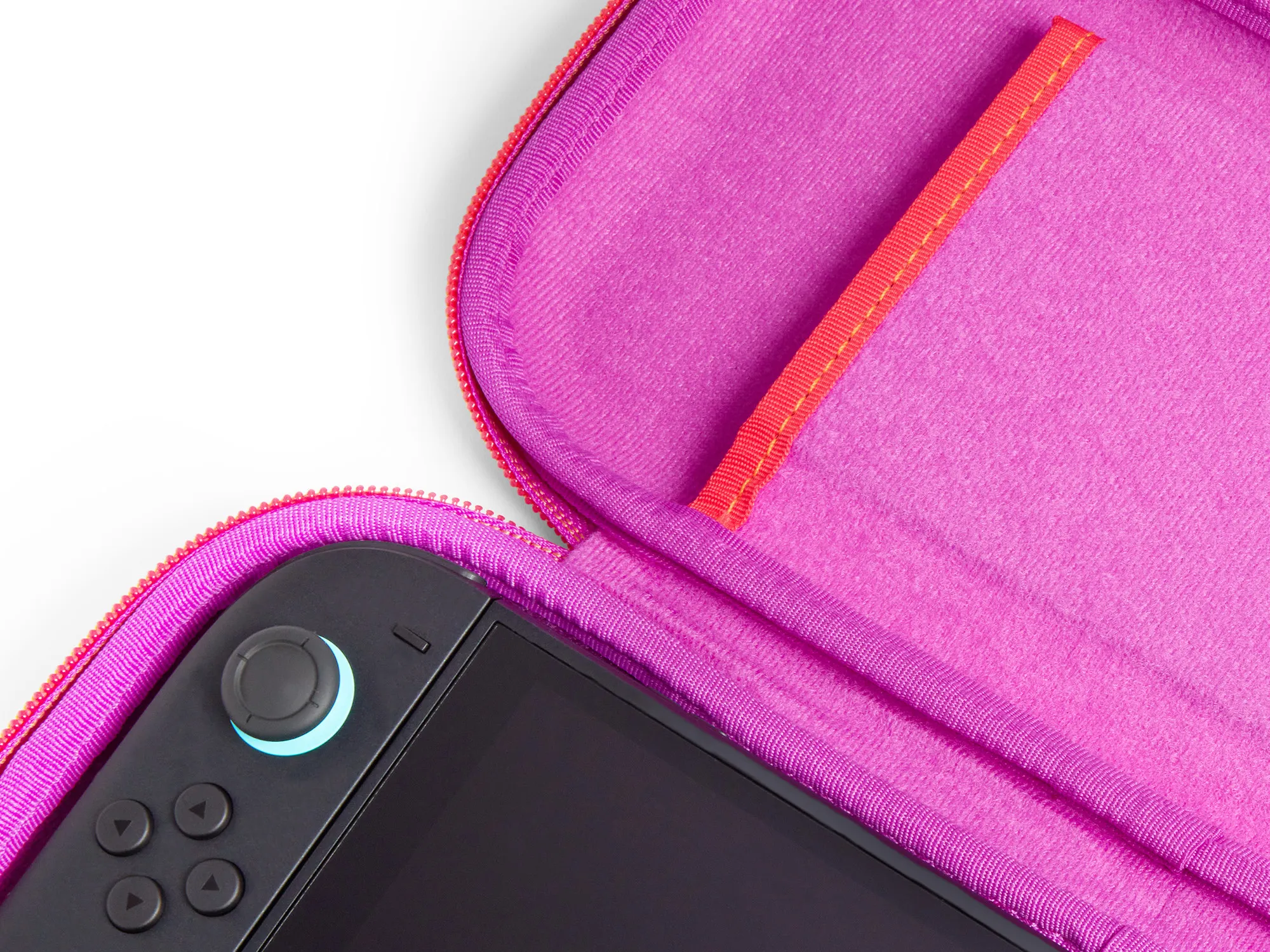 Offene pinkfarbene Hülle mit schwarzer Spielkonsole. Hülle hat roten Reißverschluss und orangefarbene Akzente. Weißer Hintergrund.