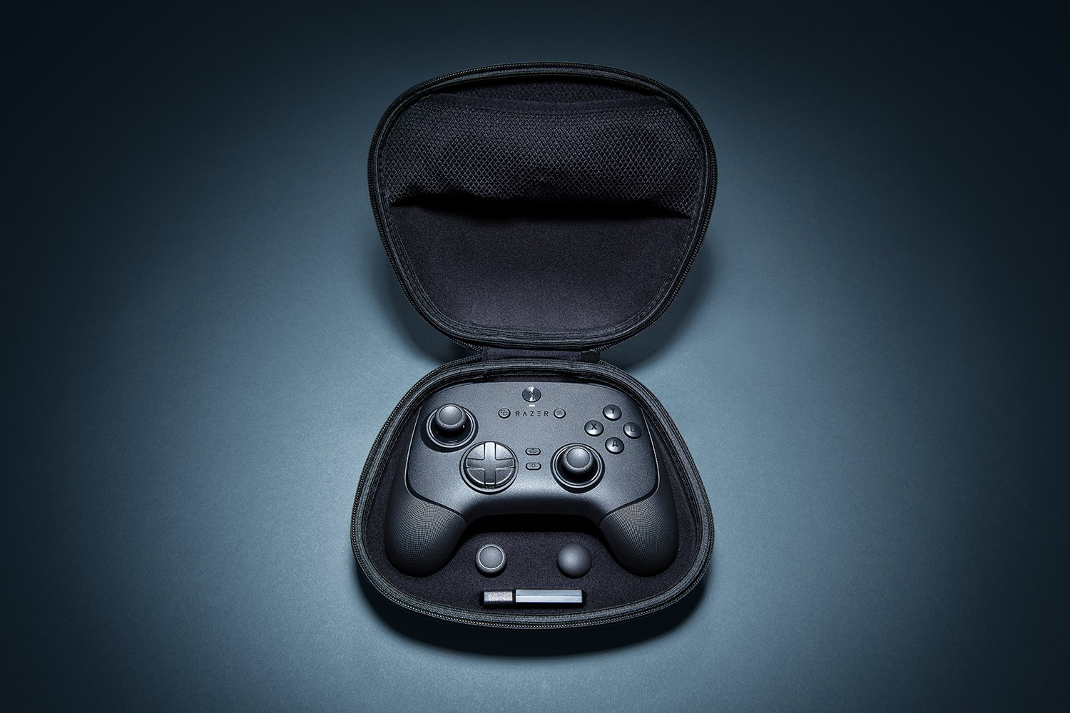 Schwarzer Razer-Gamecontroller in einem offenen schwarzen Koffer. Zusätzliche Komponenten sind im Gehäuse. Dunkelblauer Hintergrund.