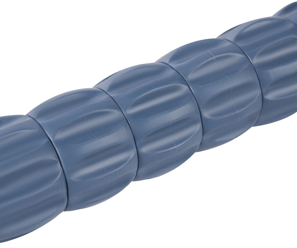 Zbliżenie niebieskiego wałka do masażu. Ma żłobienia i jest podzielony, ukośnie na białym tle.