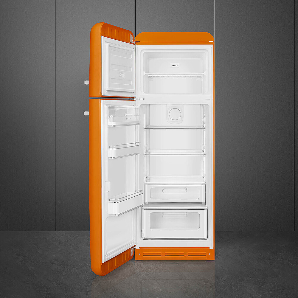 Ein offener, orangefarbener Retro-Kühlschrank zeigt das Innere. Der Hintergrund ist eine graue Wand und ein grauer Boden.