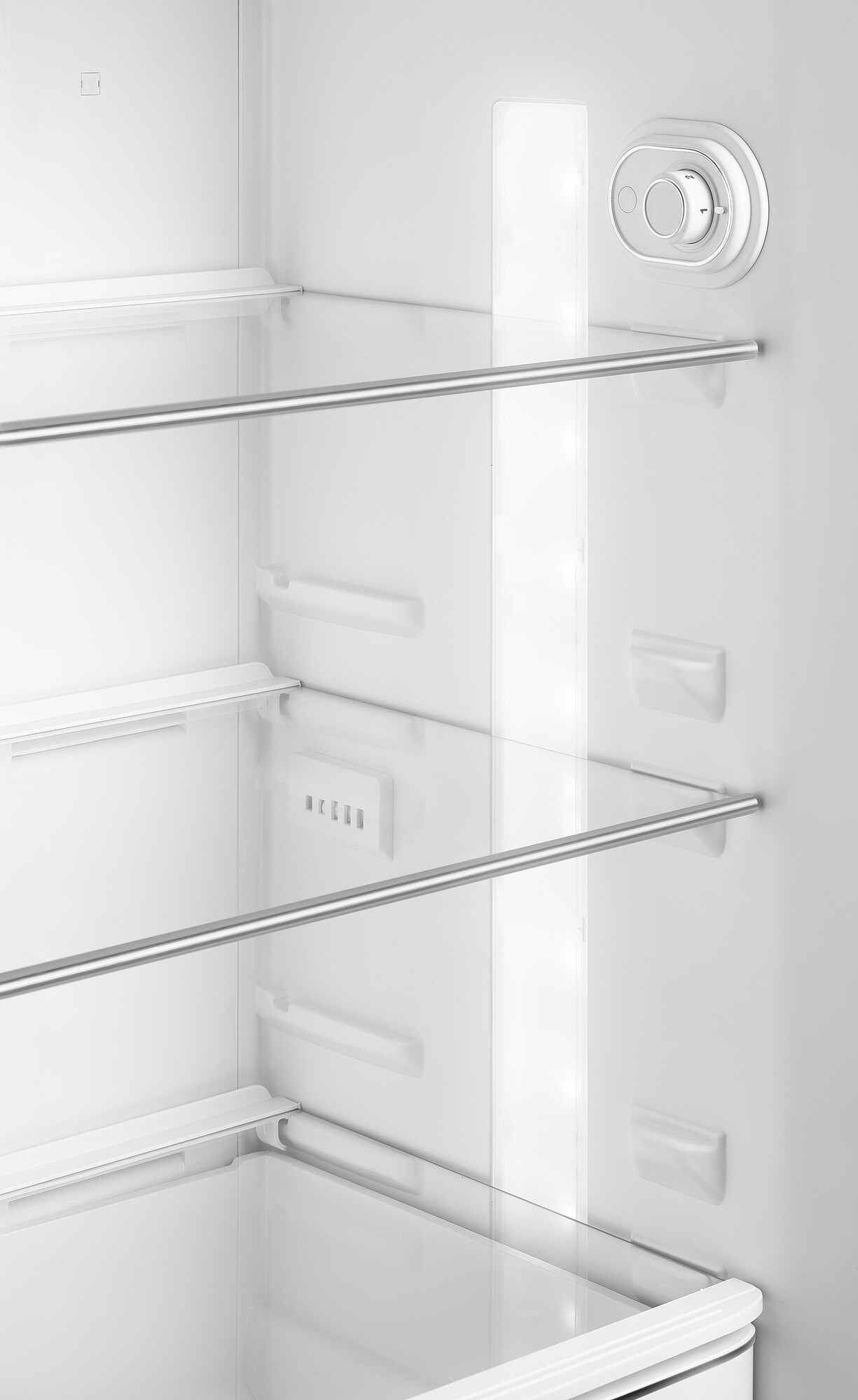Innenseite eines weißen Kühlschranks. Glasscheiben, ein Licht und ein Temperaturregler sind sichtbar.