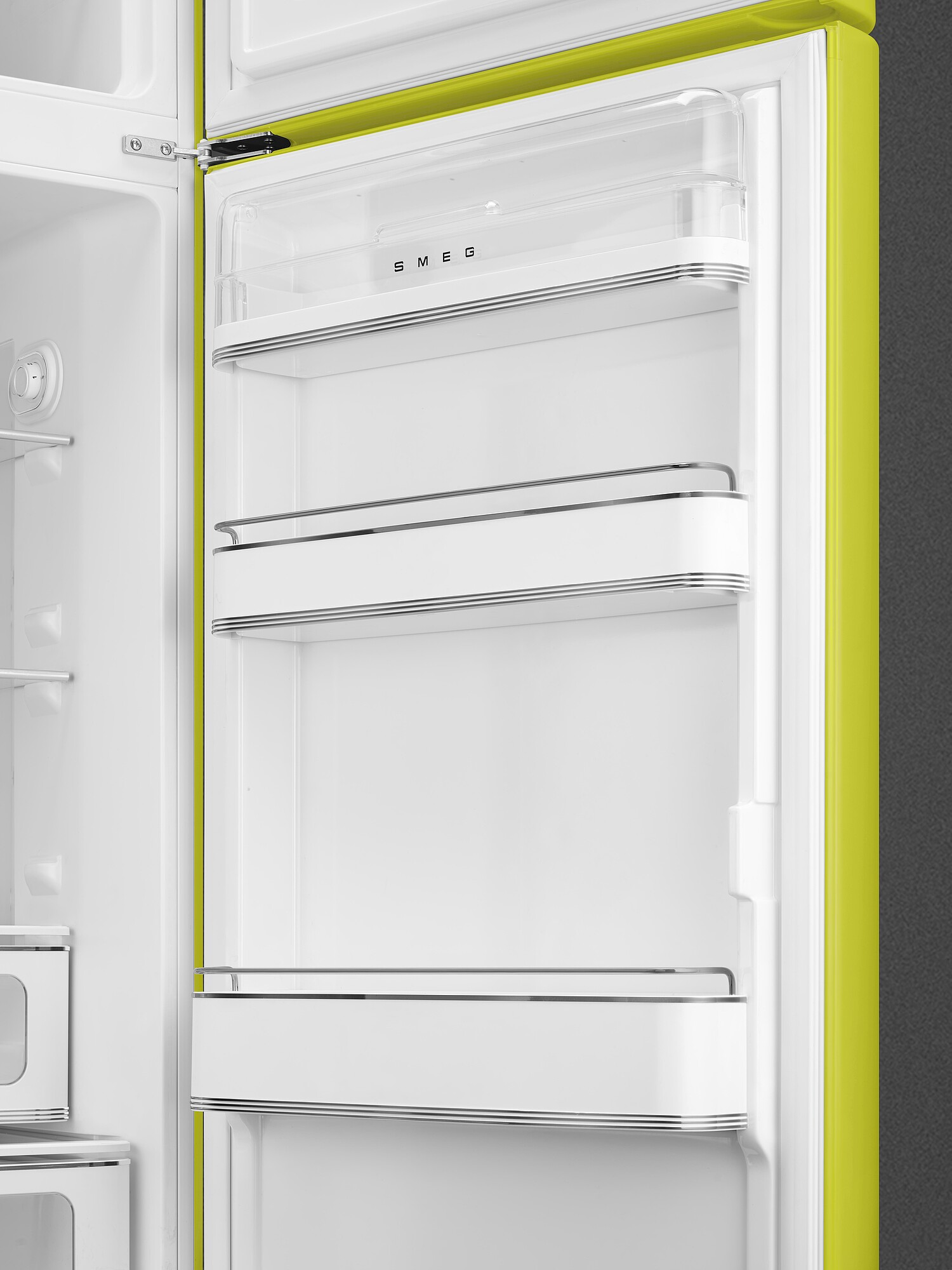 Offene Ansicht eines limettengrünen Kühlschrankinnenraums. Weiße Regale und Fächer sind sichtbar. Der Markenname SMEG steht oben.