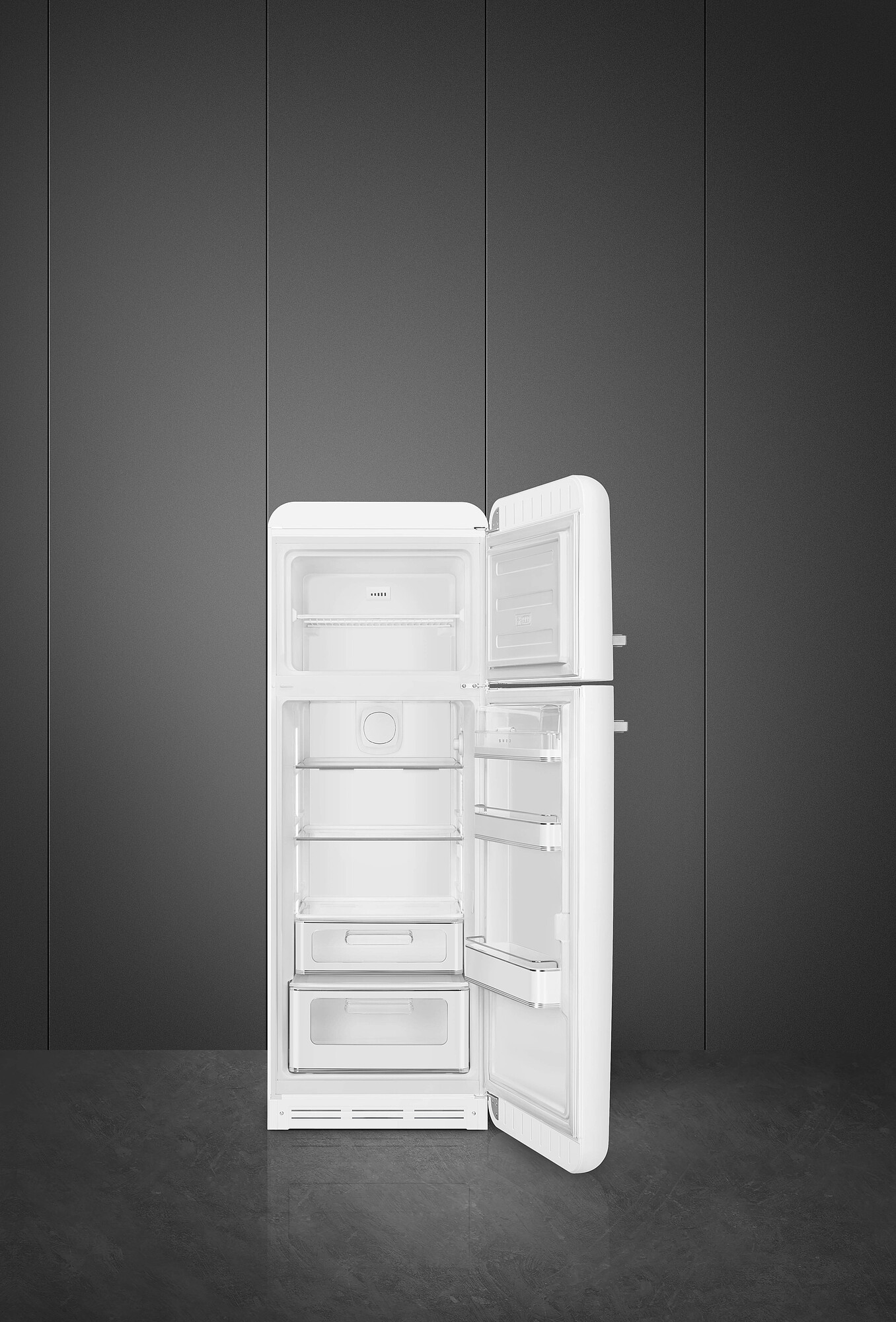 Ein weißer Kühlschrank mit geöffneter Tür, der Regale und Schubladen zeigt. Graue Wand im Hintergrund.
