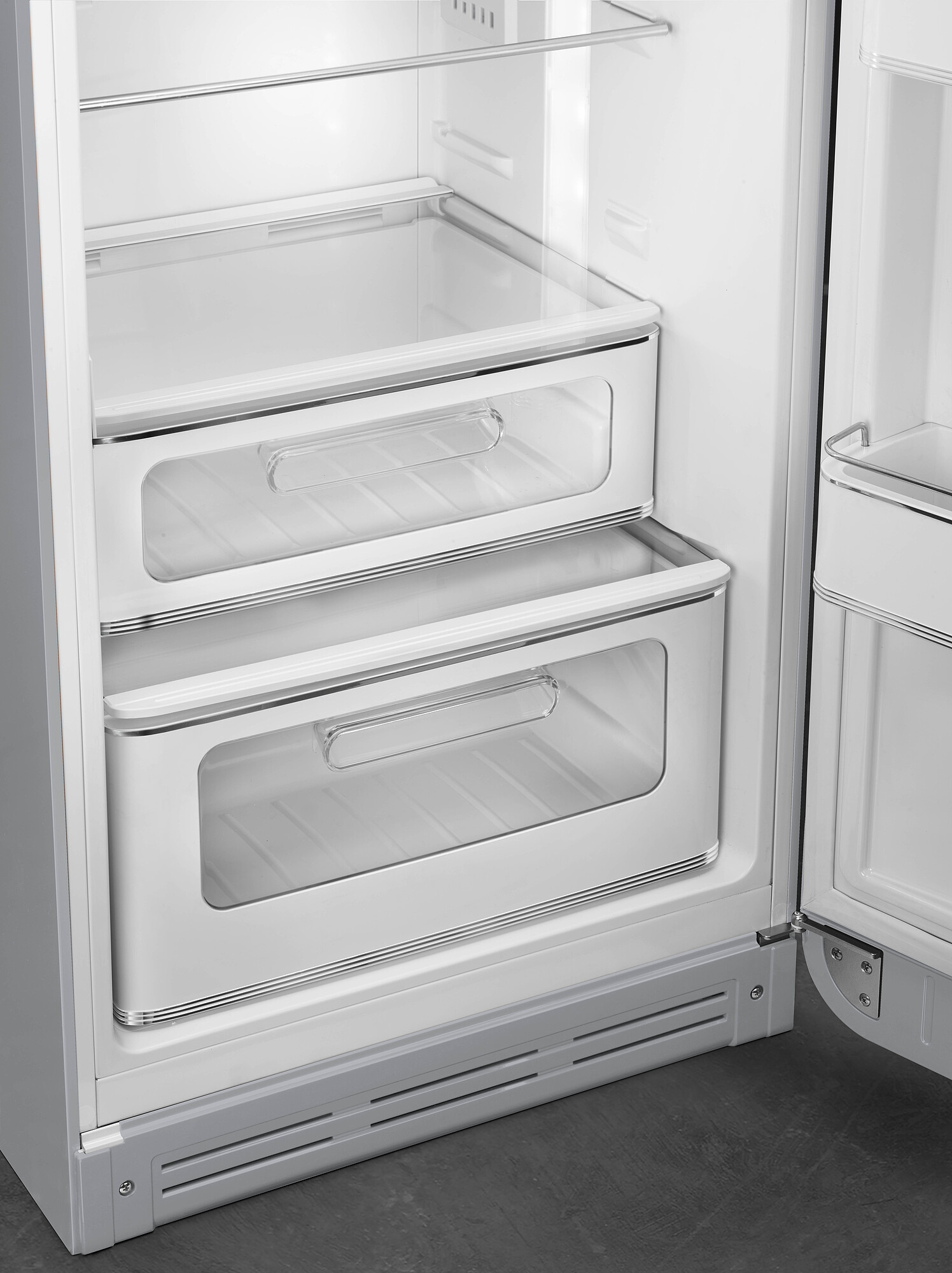 Offener weißer Kühlschrank mit zwei sichtbaren Schubladen. Die Tür steht einen Spalt breit und gibt den Innenraum frei.