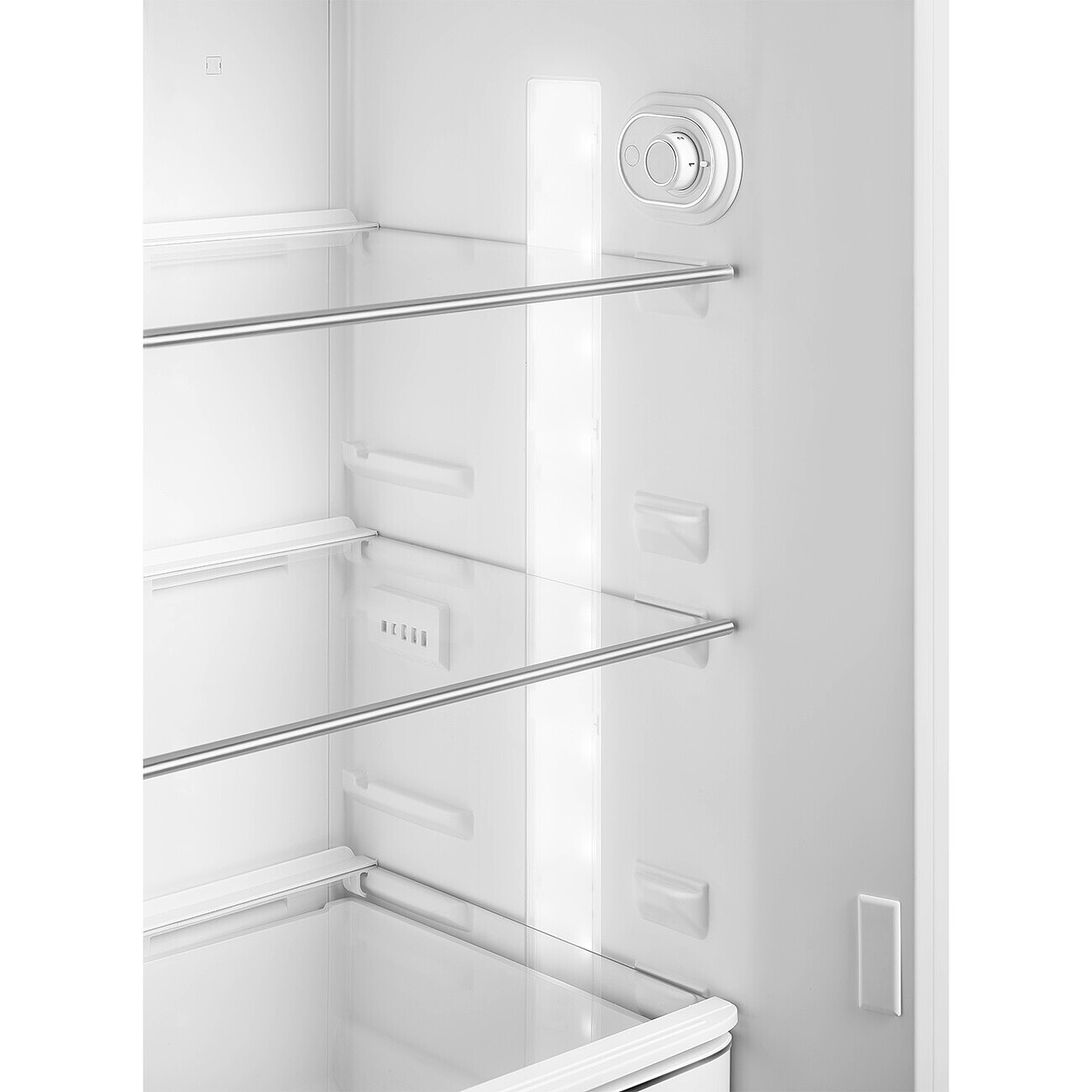 Innenraum eines weißen Kühlschranks. Glasböden mit Metallstangen. Ein Bedienknopf und ein Licht sind rechts sichtbar.