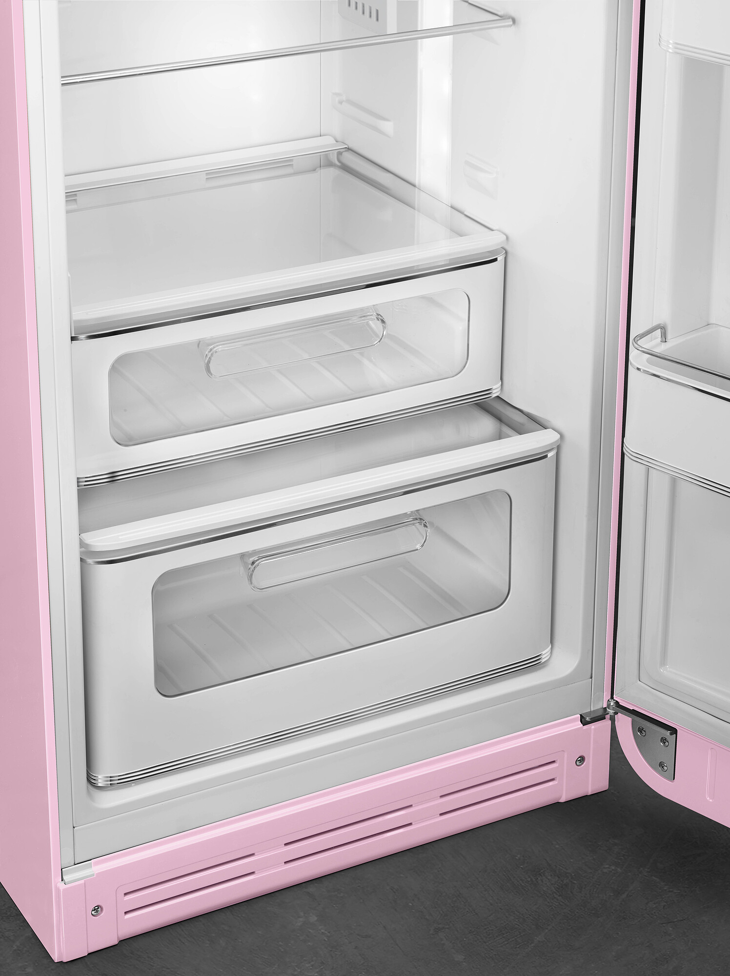 Offener rosa Kühlschrank mit zwei Schubladen. Innenraum ist weiß mit Glasböden. Tür steht offen.