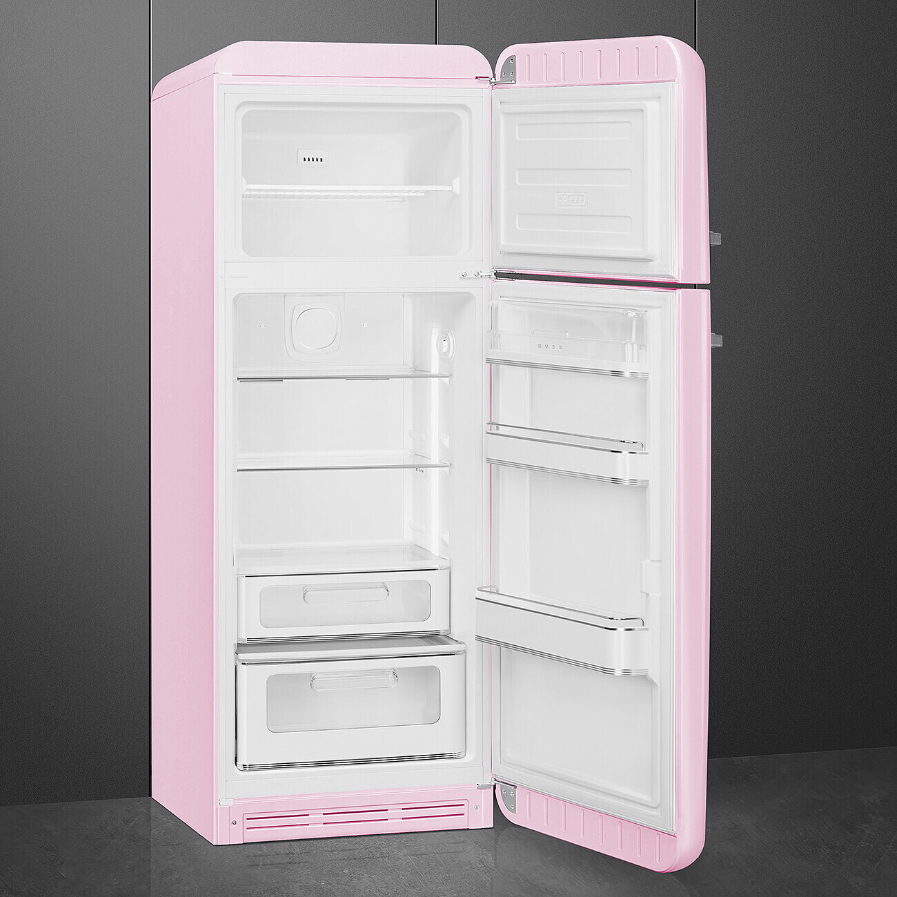 Ein rosa Retro-Kühlschrank mit geöffneten Türen. Im Inneren befinden sich Regale und Schubladen. Graue Wand im Hintergrund.