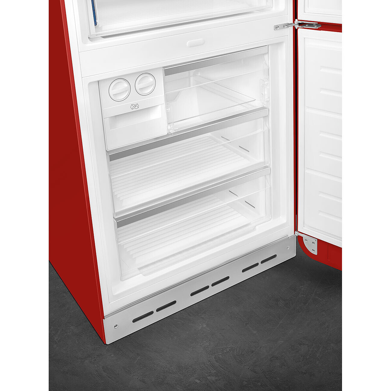 Offener roter Kühlschrank mit weißem Innenraum. Transparente Regale und Schubladen sind sichtbar. Die Tür steht auf dunkler Oberfläche offen.