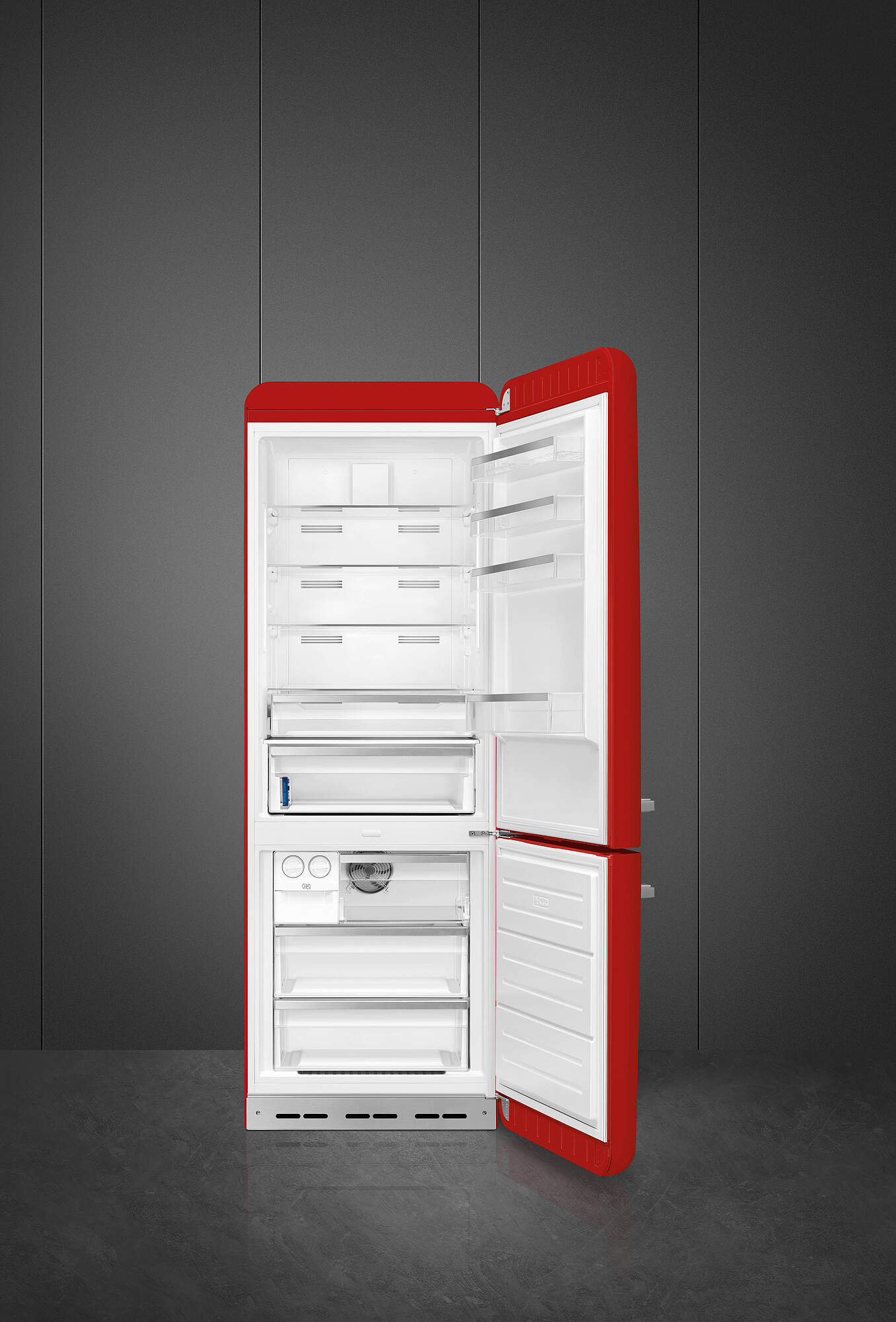 Ein roter Kühlschrank mit offenen Türen, der Regale und Schubladen zeigt. Er steht vor einer dunkelgrauen Wand und einem Boden.