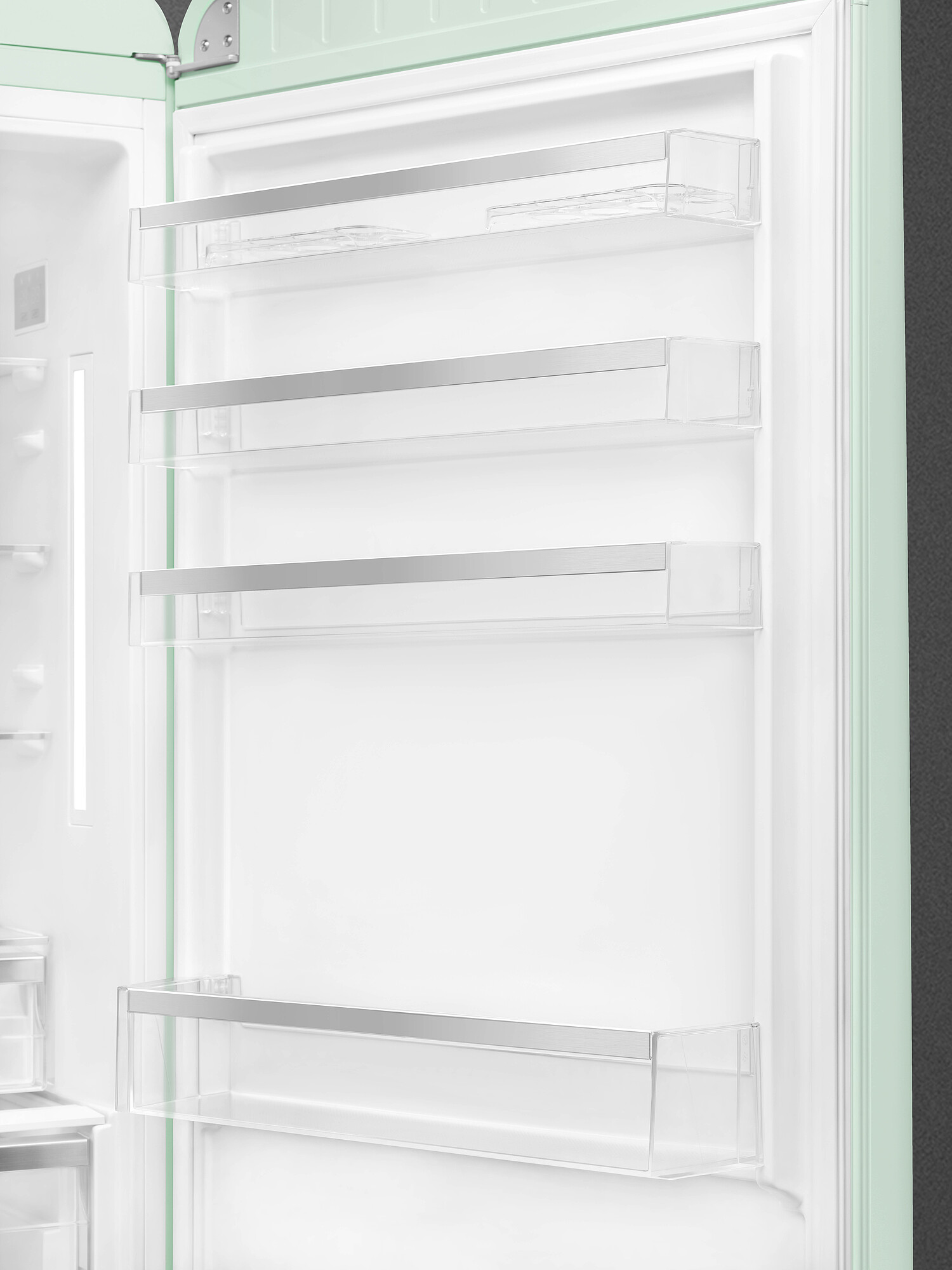 Offener Kühlschrankinnenraum. Klare Regale mit Metallbesatz. Minzgrüner Türrahmen, weißer Innenraum. Leer, sauber und modernes Design.