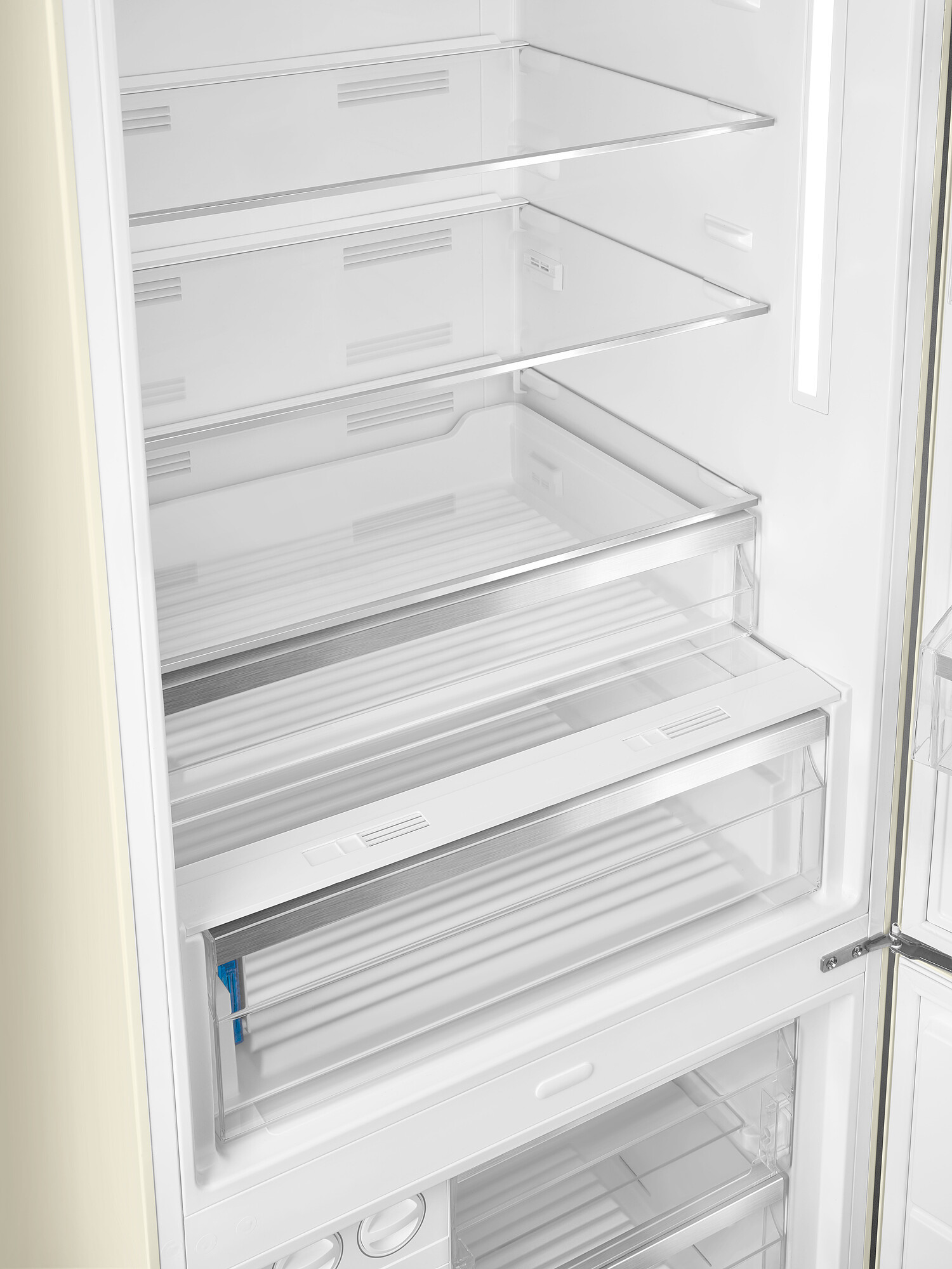 Offener Kühlschrankinnenraum mit Regalen, Schubladen und Licht. Der Kühlschrank ist cremefarben.
