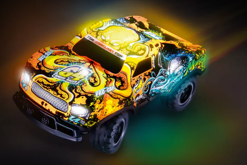 Ein buntes Spielzeugauto mit gelben, orangen und blauen Akzenten. Es hat ein detailliertes Design und wird von Lichtern beleuchtet.