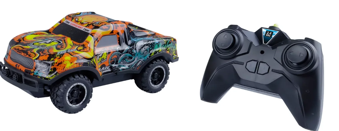 Ein orangefarbener und blauer Spielzeug-LKW mit Controller. Der LKW hat schwarze Räder und ein Graffiti-Design.