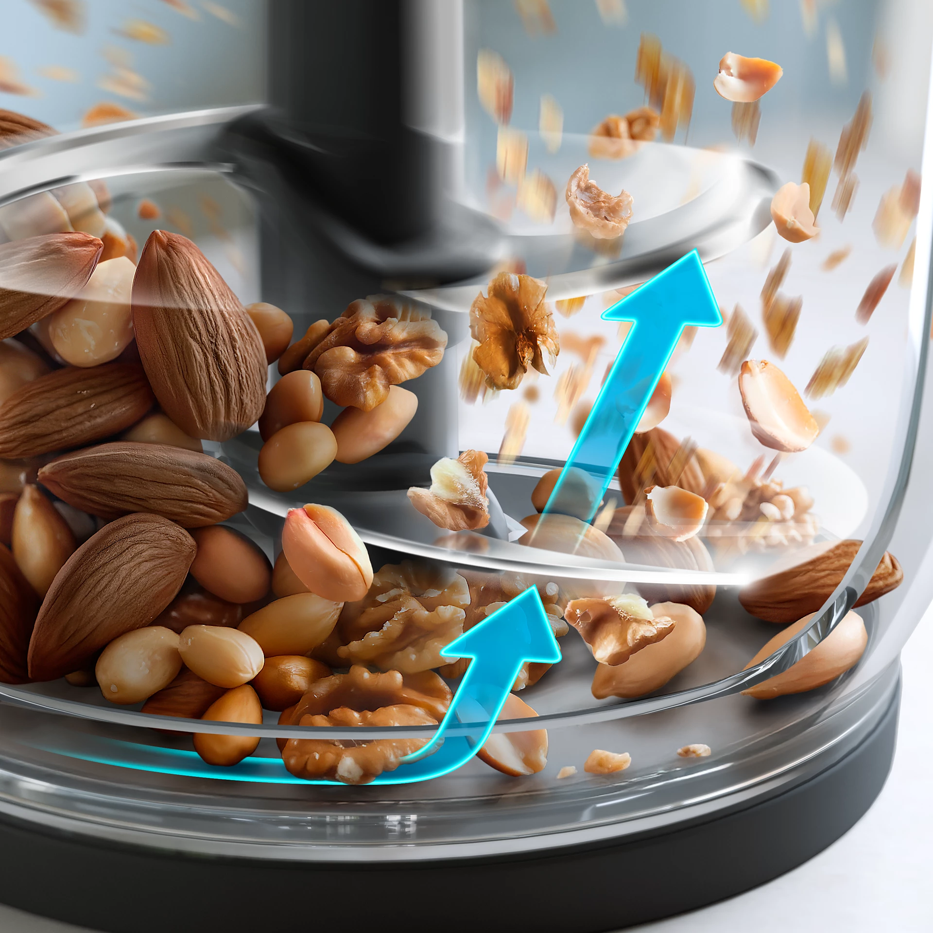 Un procesador de alimentos con almendras, cacahuetes y nueces. Flechas azules indican picado.