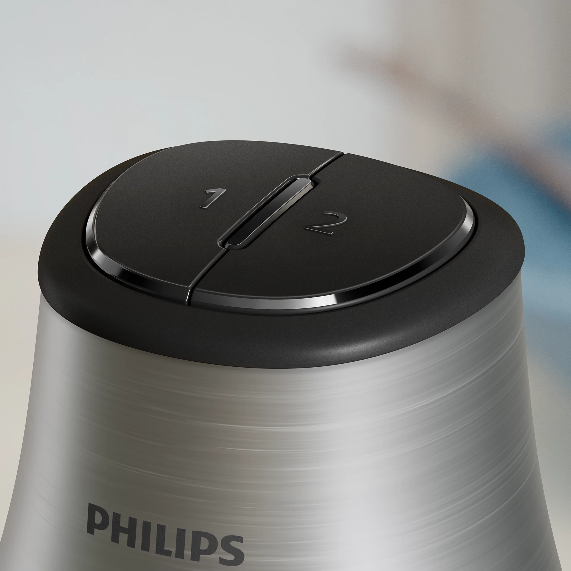 Primer plano de un electrodoméstico Philips con tapa negra y los números 1 y 2. Cuerpo plateado metálico.