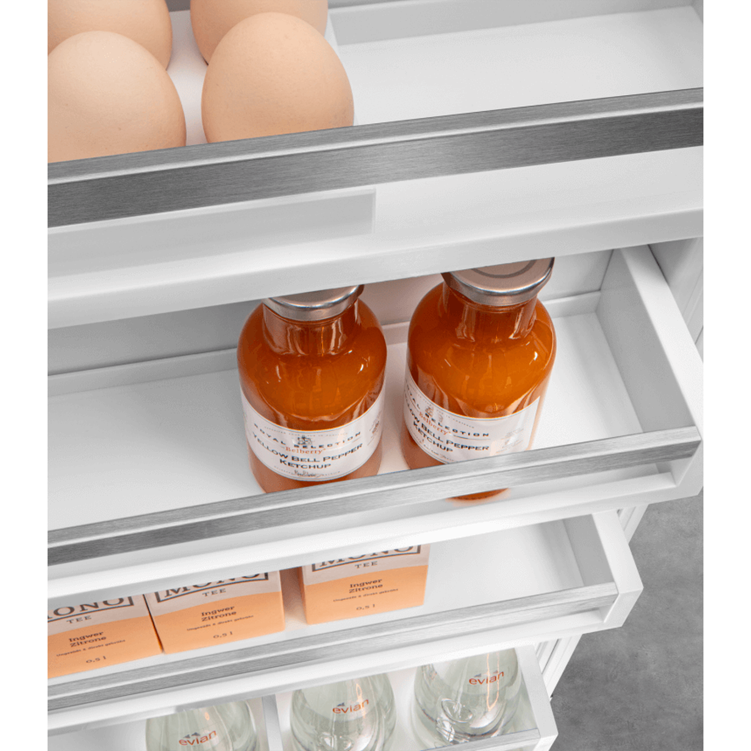 Inside a refrigerator: eggs, orange bottles, tea boxes, and water glasses are visible on different shelves.