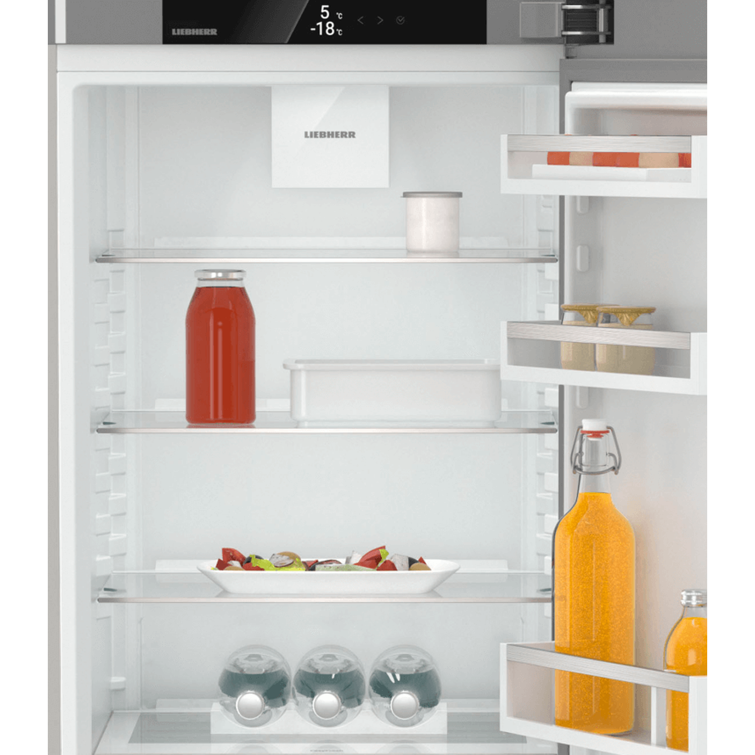 Open refrigerator filled with food: juice bottles, salad, water bottles, and a jar. Temperature display at the top.