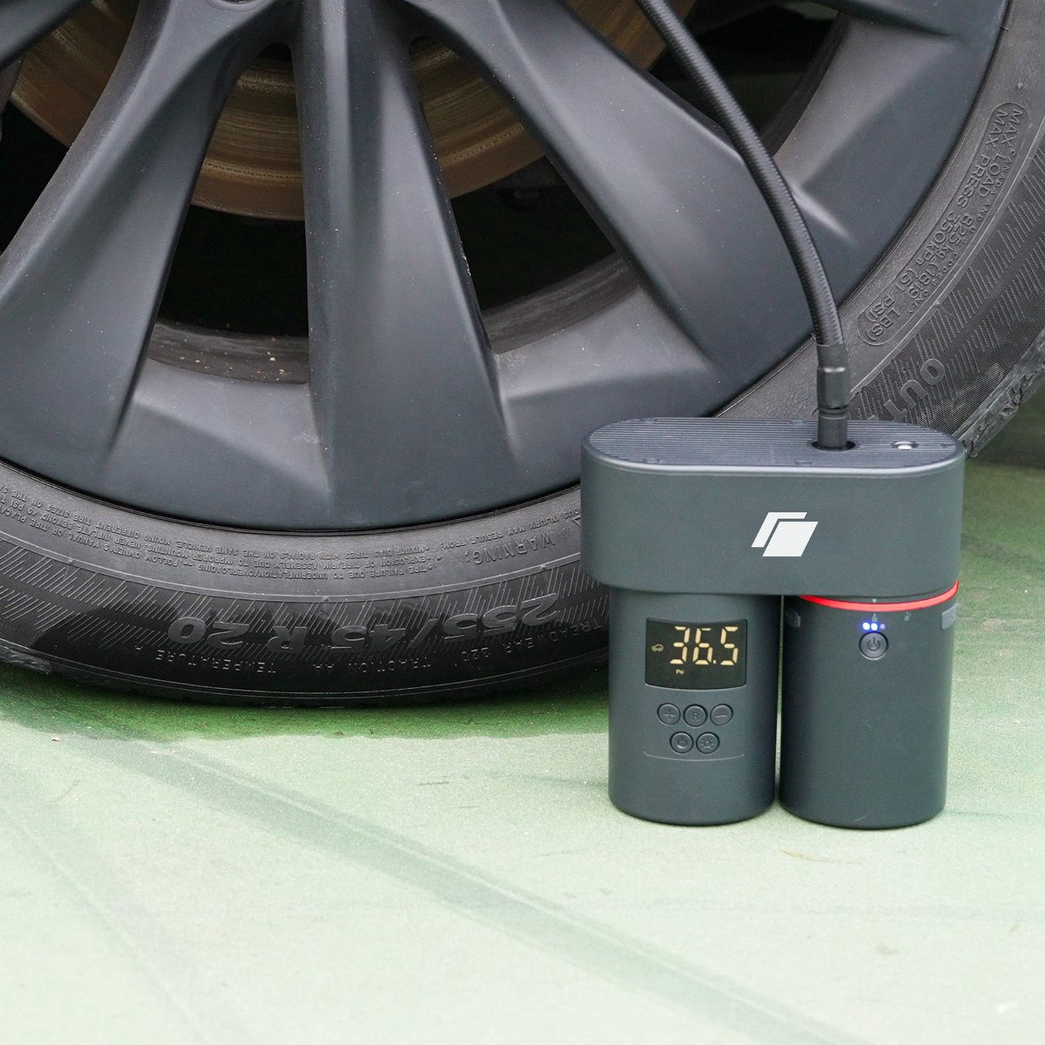 A tire inflator connected to a car tire. The inflator displays 36.5. Tire specs are visible.