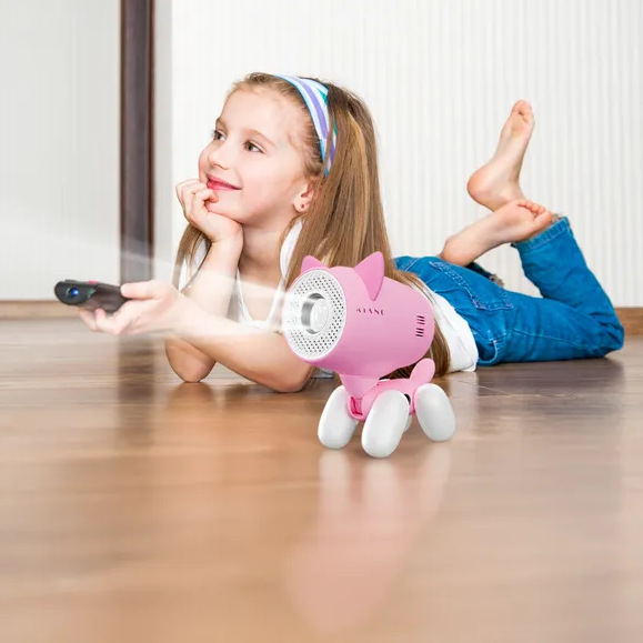 Dziewczyna leży na podłodze i patrzy na projektor. Różowy projektor w kształcie kota jest przed nią. Trzyma pilota.