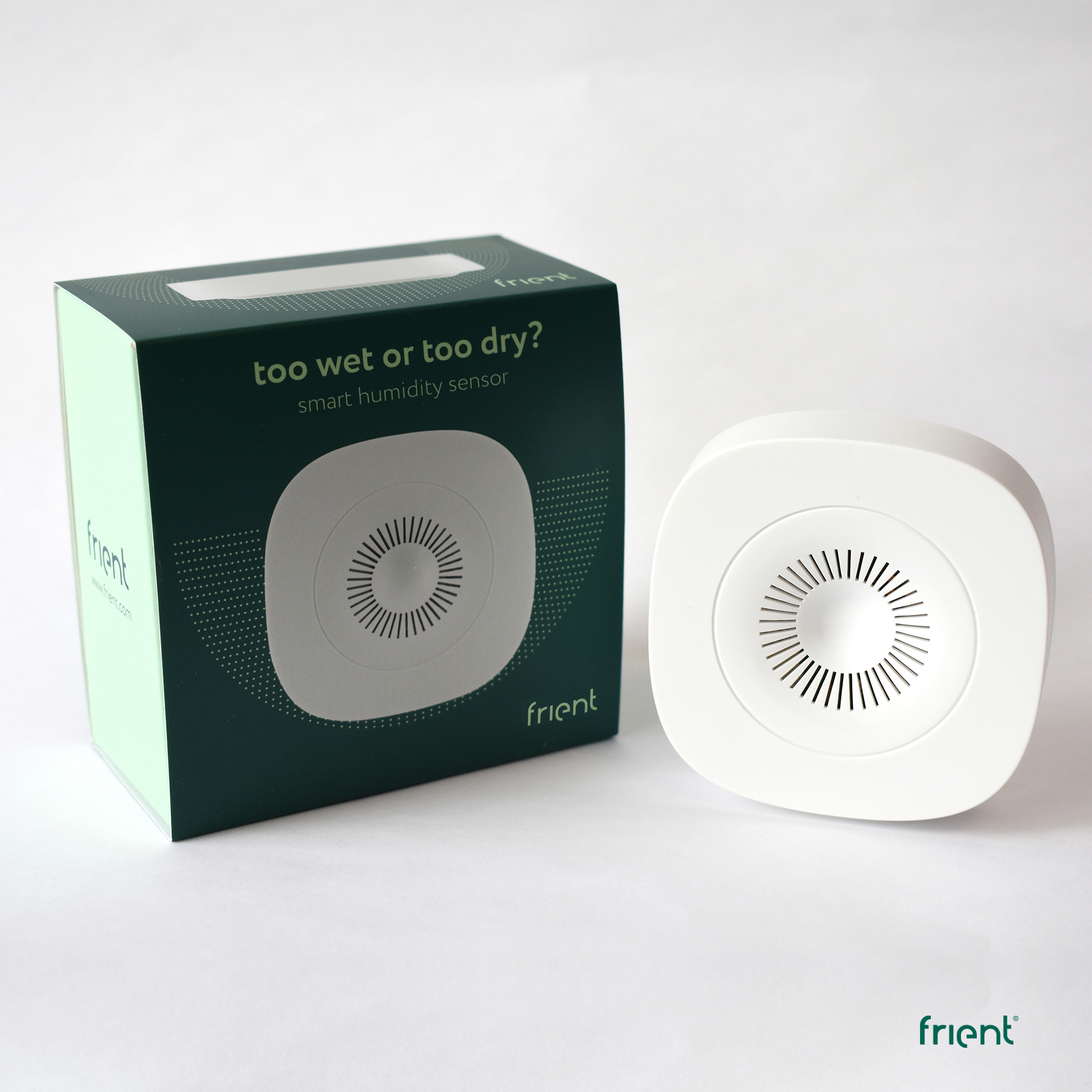 Ein weißer intelligenter Feuchtigkeitssensor und seine Box. Die Box ist grün mit weißem Text. Beide haben das "frient" Logo.