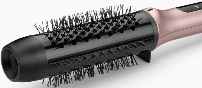 Un primo piano di una spazzola per capelli nera e oro rosa con setole. Lo sfondo è bianco.