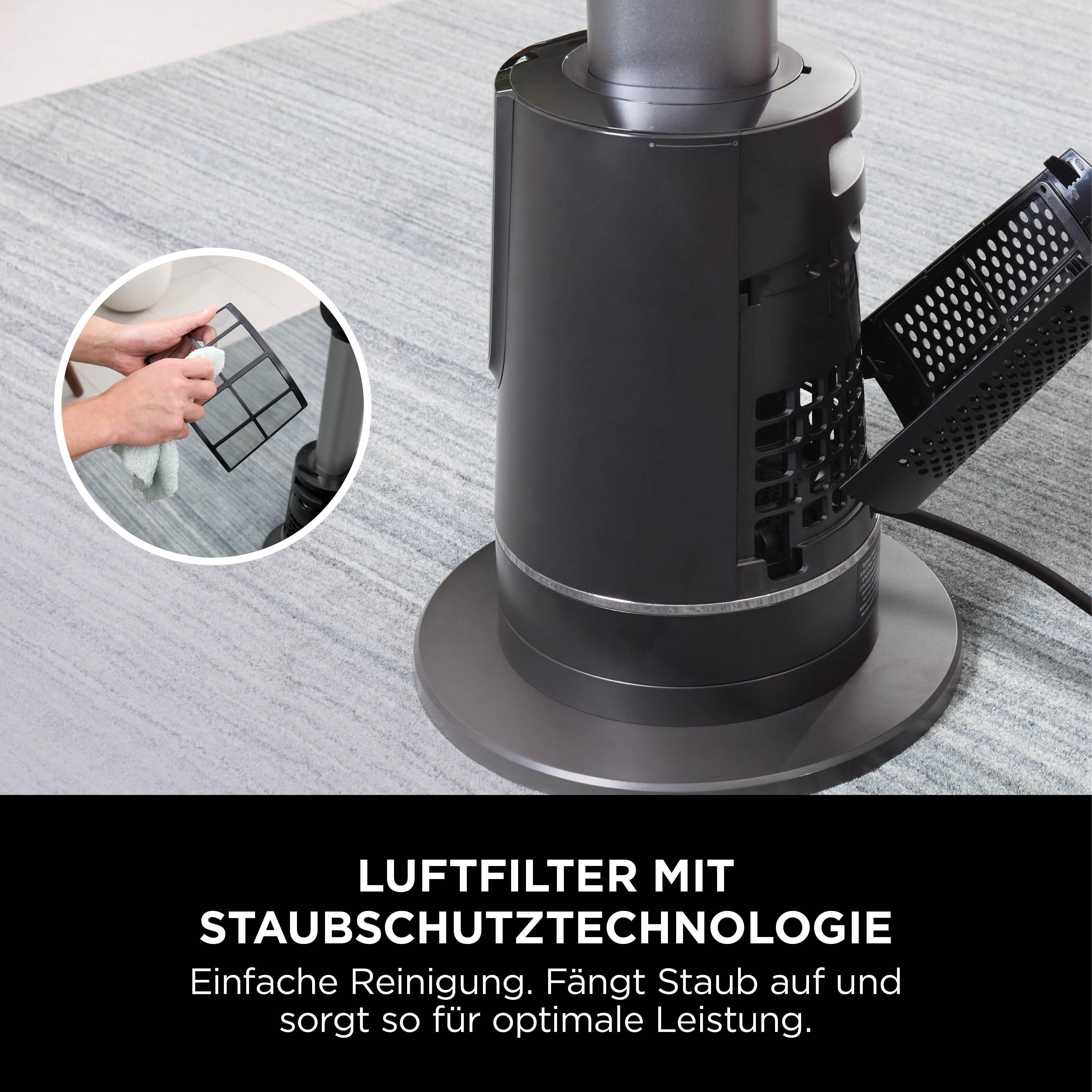 Ein schwarzer Luftreiniger mit einem gereinigten Filter. Eine Person wischt den Filter mit einem Tuch ab.