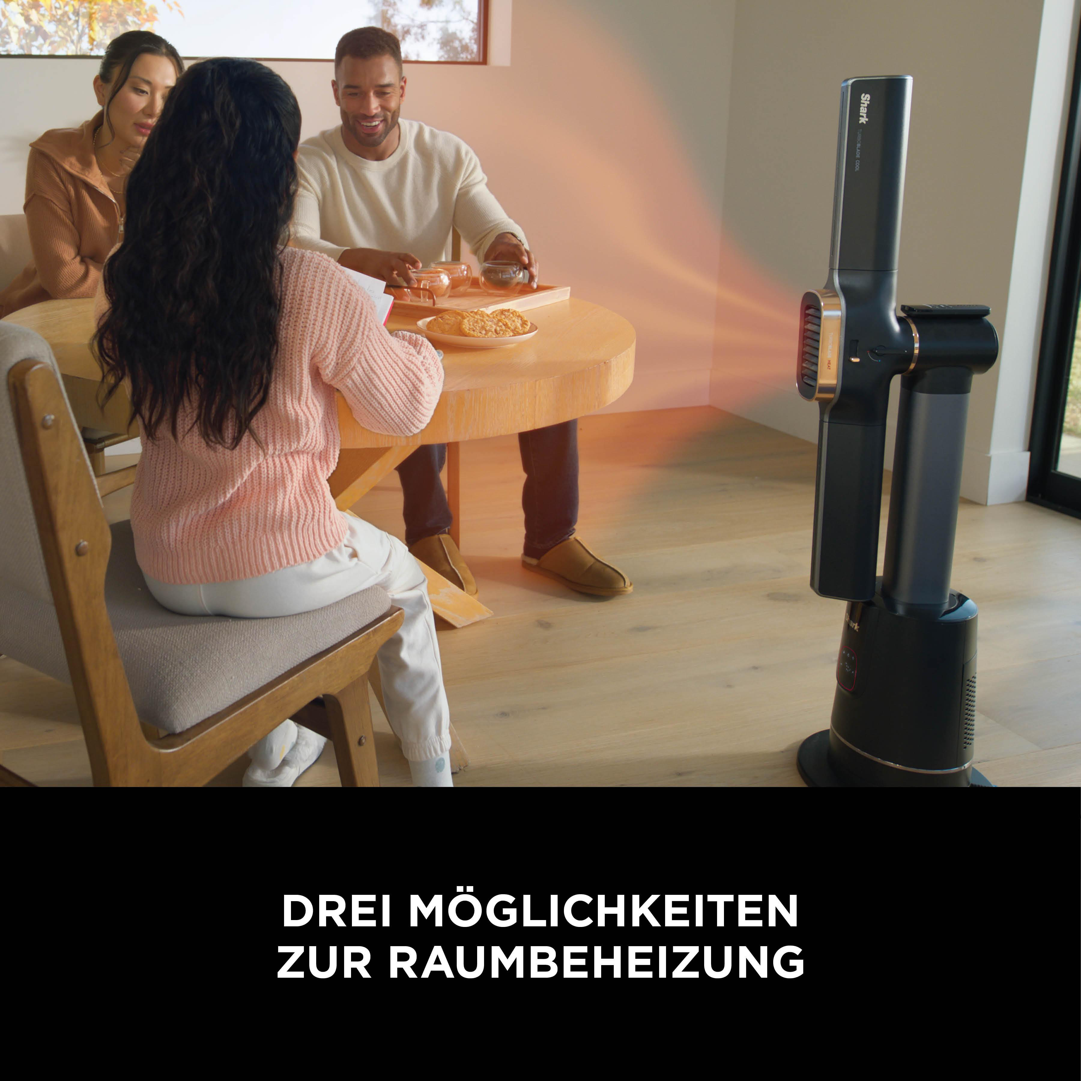 Leute sitzen an einem Tisch. Ein schwarzes und goldenes Heizgerät steht daneben. Kekse und Getränke stehen auf dem Tisch.