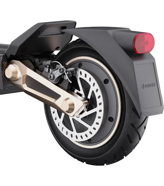 Primer plano de la rueda trasera de un patinete eléctrico con freno de disco. Neumático negro, disco plateado, brazo dorado, guardabarros negro con luz roja.