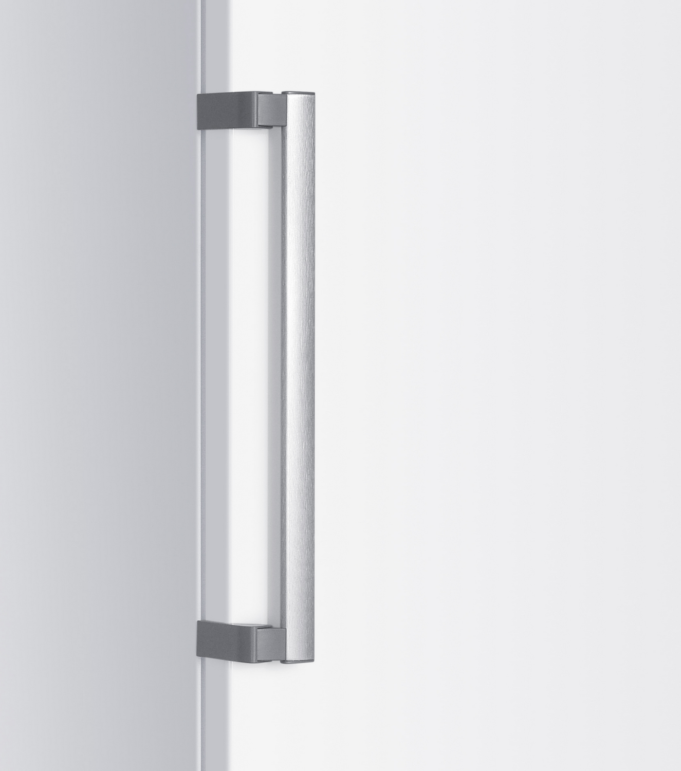 Primer plano de una puerta blanca con un tirador plateado. El tirador es rectangular y está orientado verticalmente.