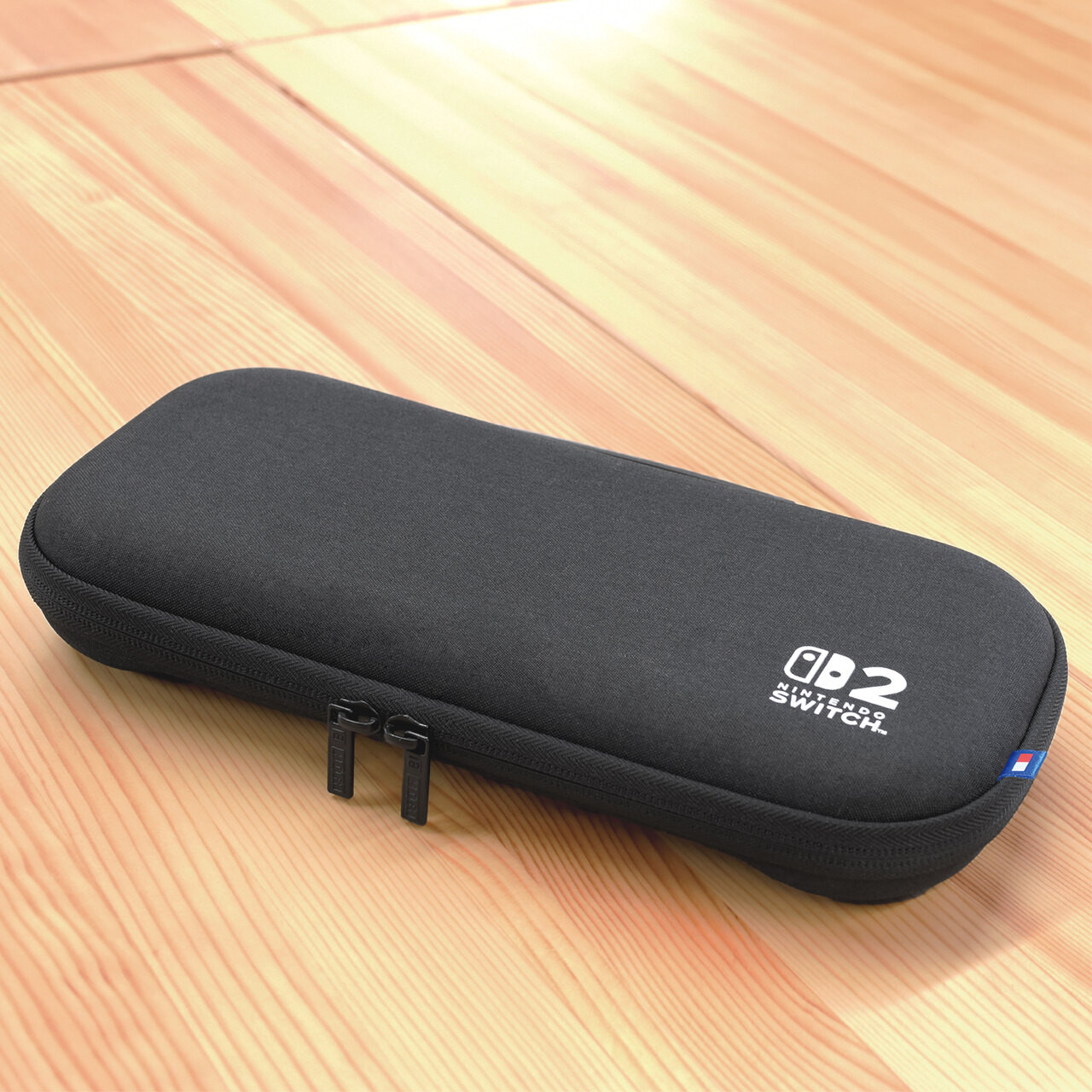 Una custodia nera per Nintendo Switch su una superficie di legno. La custodia è rettangolare con una cerniera. Il logo Nintendo Switch è visibile.