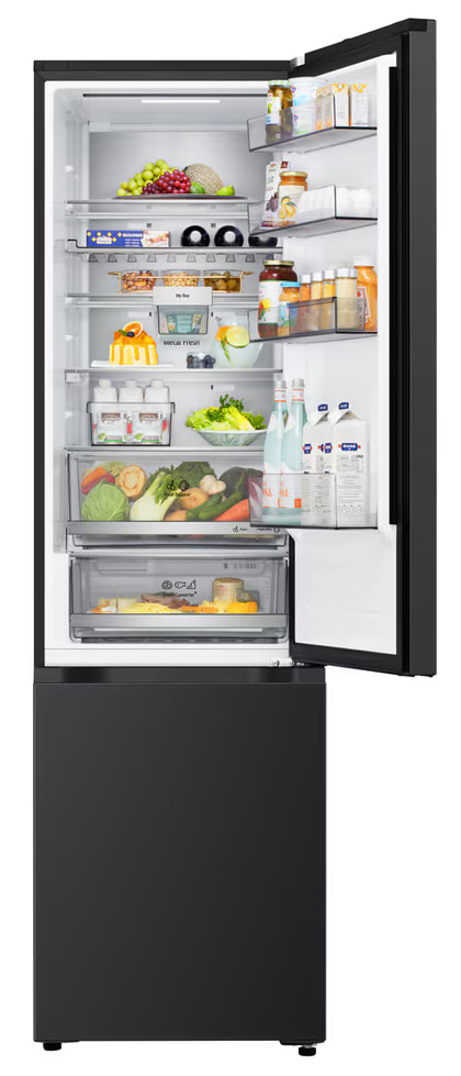 Otwarta lodówka wypełniona jedzeniem: owoce, warzywa, napoje i produkty mleczne. Czarny wygląd zewnętrzny, białe wnętrze. Drzwi uchylone.