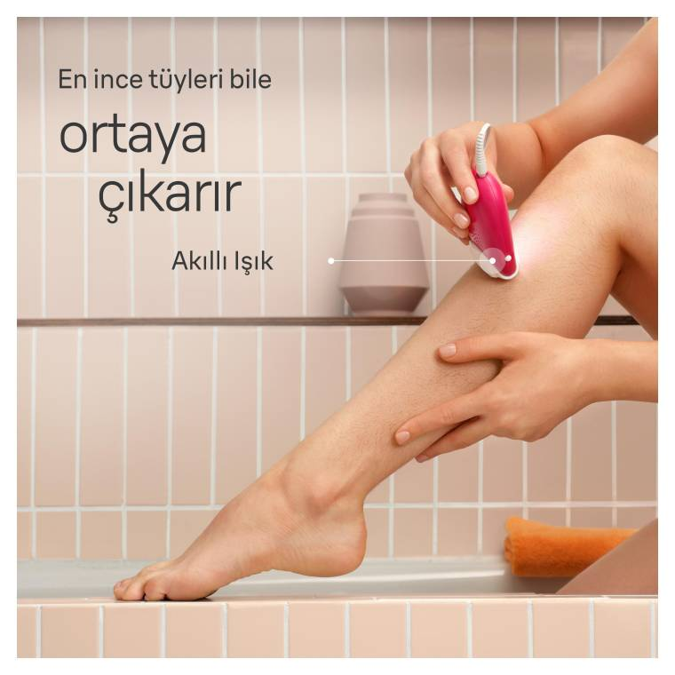 Bir kişi bacağını pembe bir epilatörle tıraş ediyor. Bacak bir küvette. Arka planda metin ve küçük bir vazo var.
