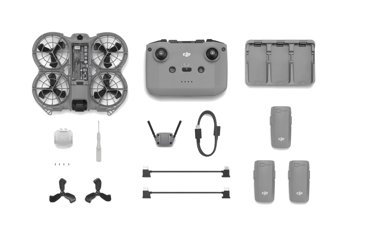 Komponenty drona DJI: korpus drona, pilot, baterie, ładowarka, kable, śmigła, śrubokręt i inne akcesoria.