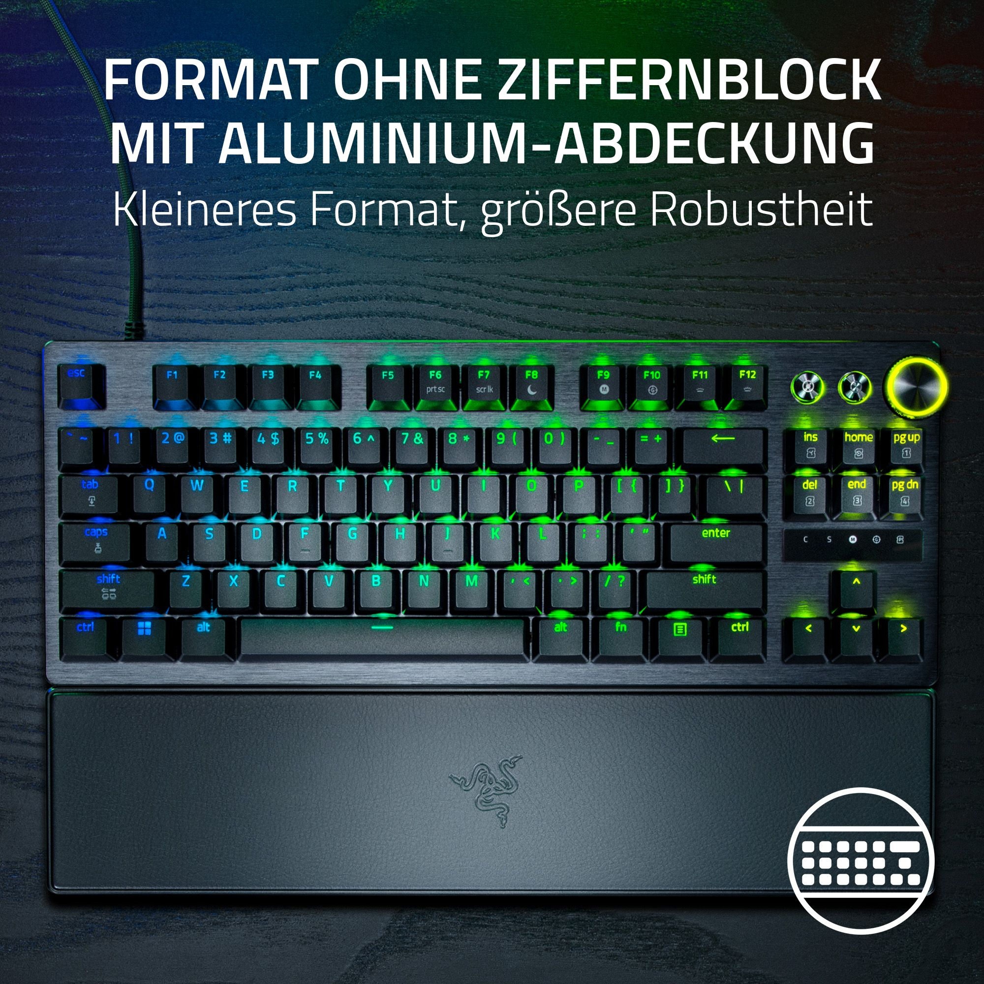 Schwarze Tastatur mit grün hinterleuchteten Tasten. Enthält eine Handgelenkauflage. Text auf Deutsch oben.