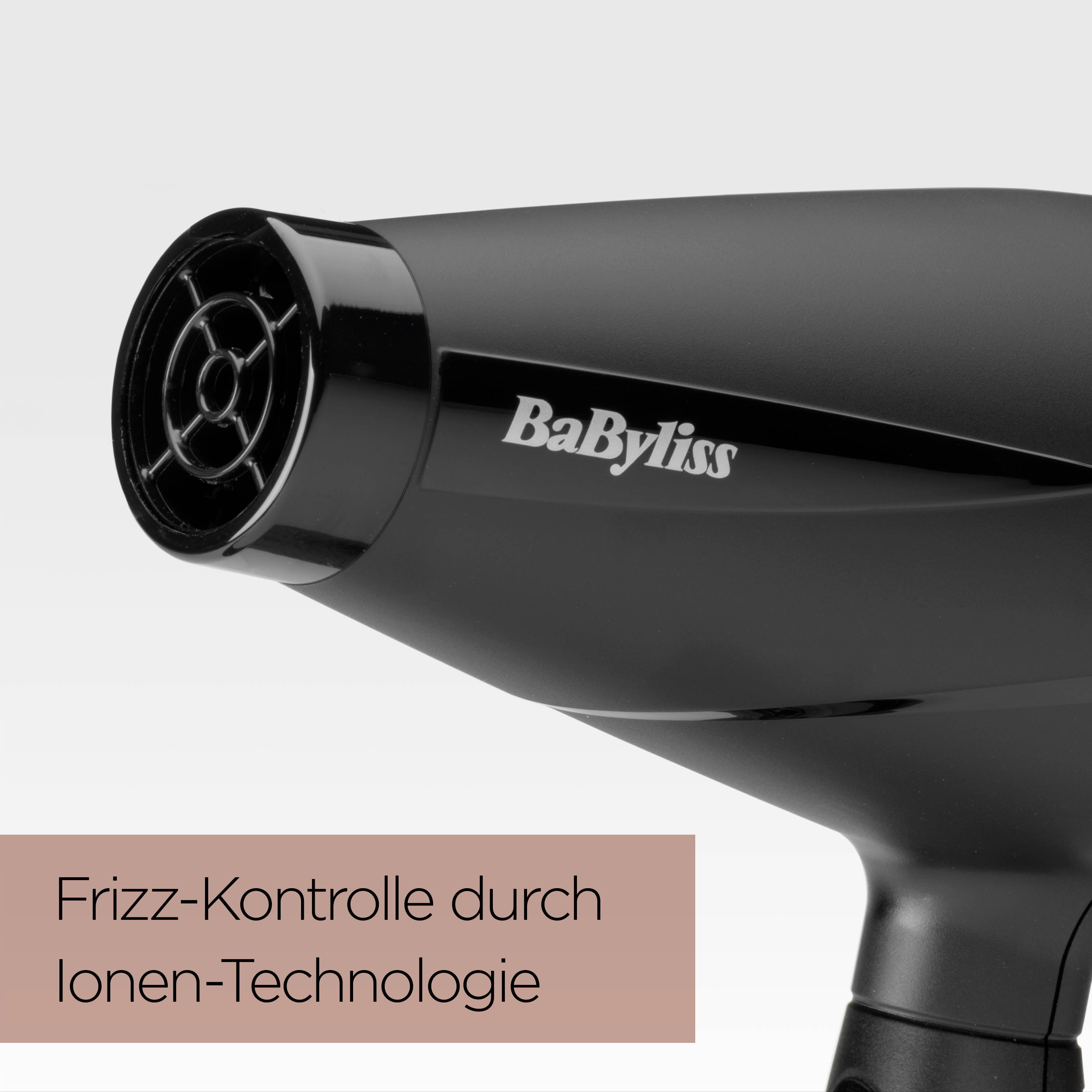 Nahaufnahme eines schwarzen BaByliss-Haartrockners, angewinkelt. Text auf Deutsch: Frizz-Kontrolle durch Ionen-Technologie.