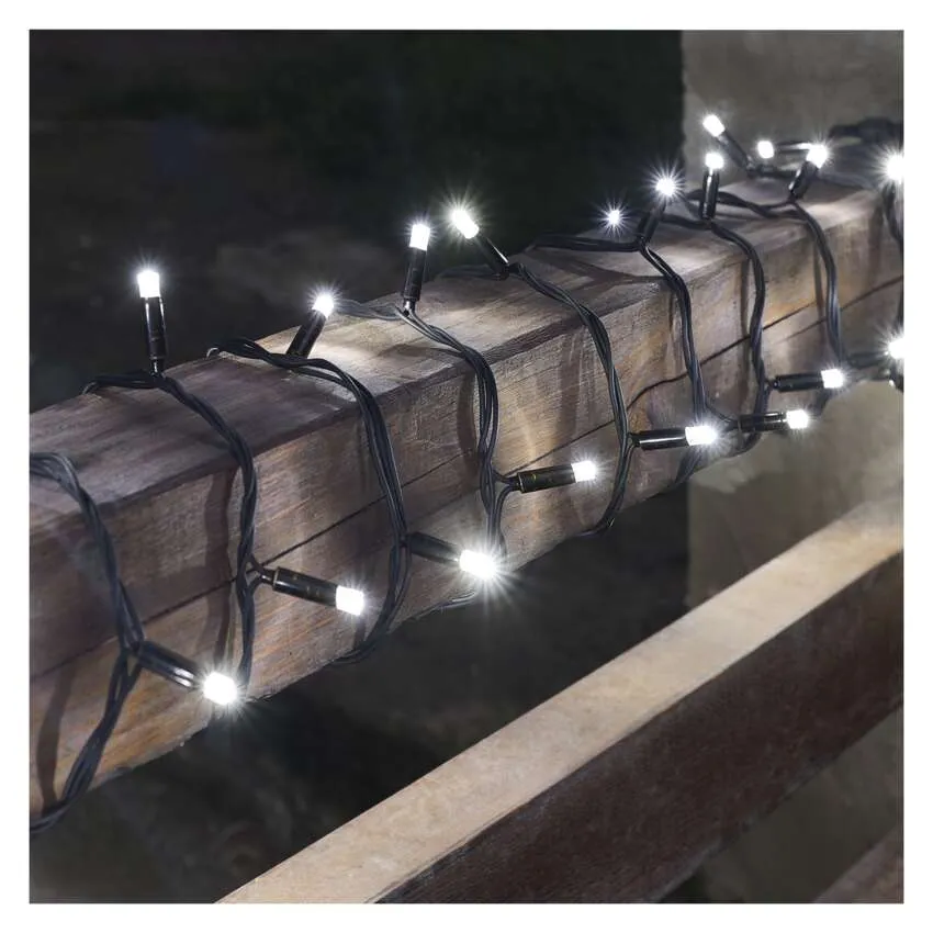 Fehér LED-es fénysorok egy fa gerendára tekerve. A lámpák világítanak, a háttér sötét.