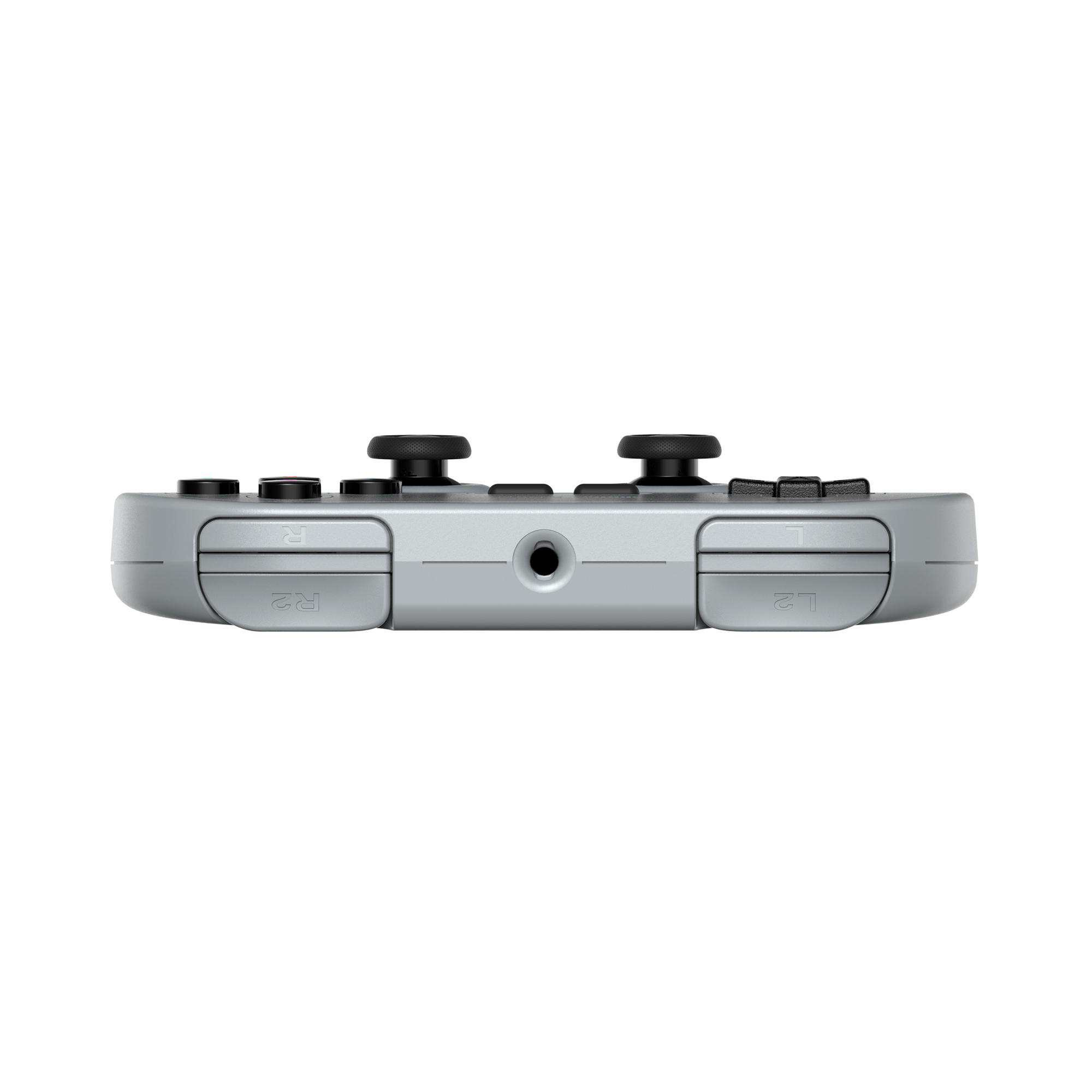 Grauer Game-Controller, von unten gesehen. Er hat schwarze Analog-Sticks und Tasten. Der Hintergrund ist weiß.