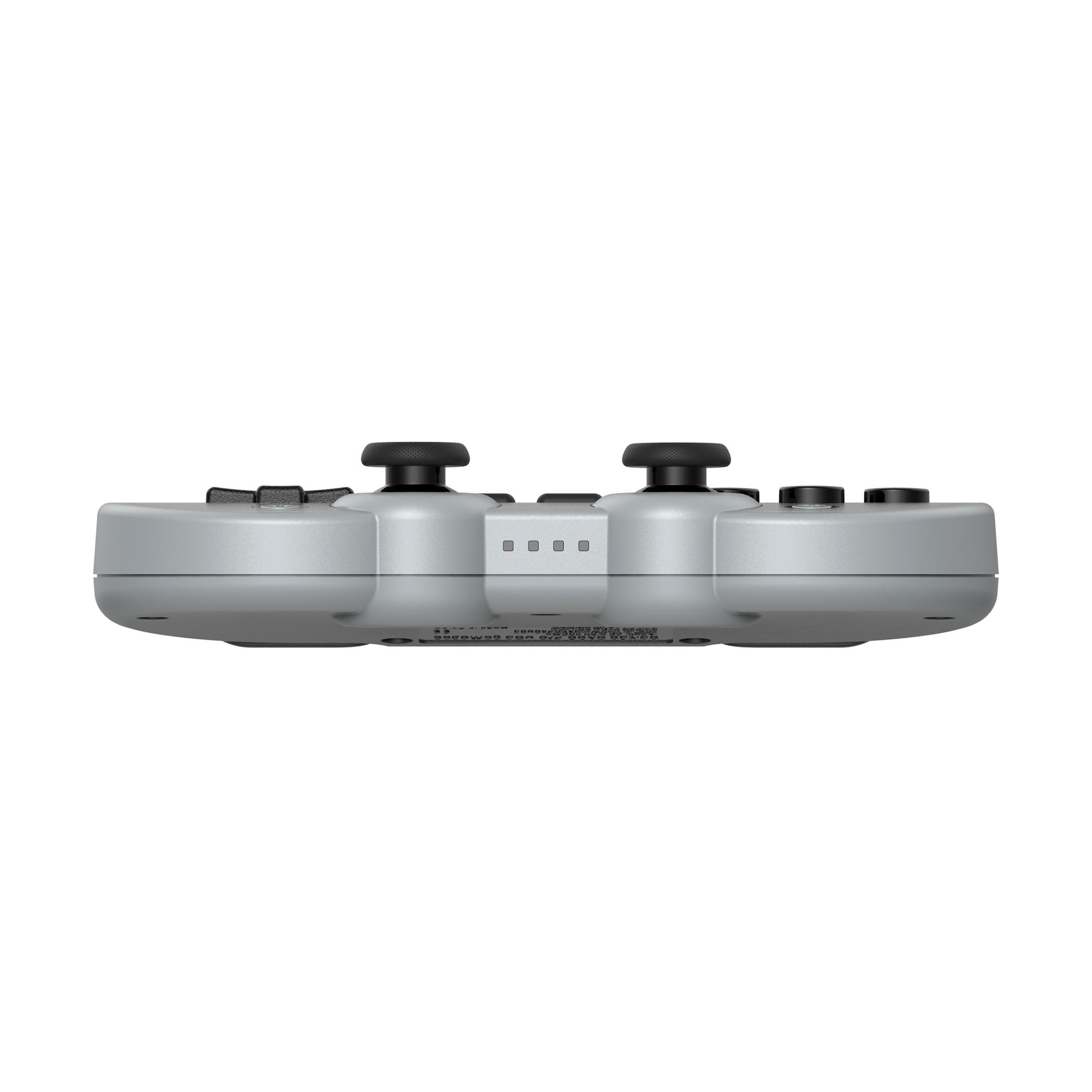 Ein silberner Spielcontroller. Er hat schwarze Analog-Sticks und -Tasten. Der Hintergrund ist weiß.