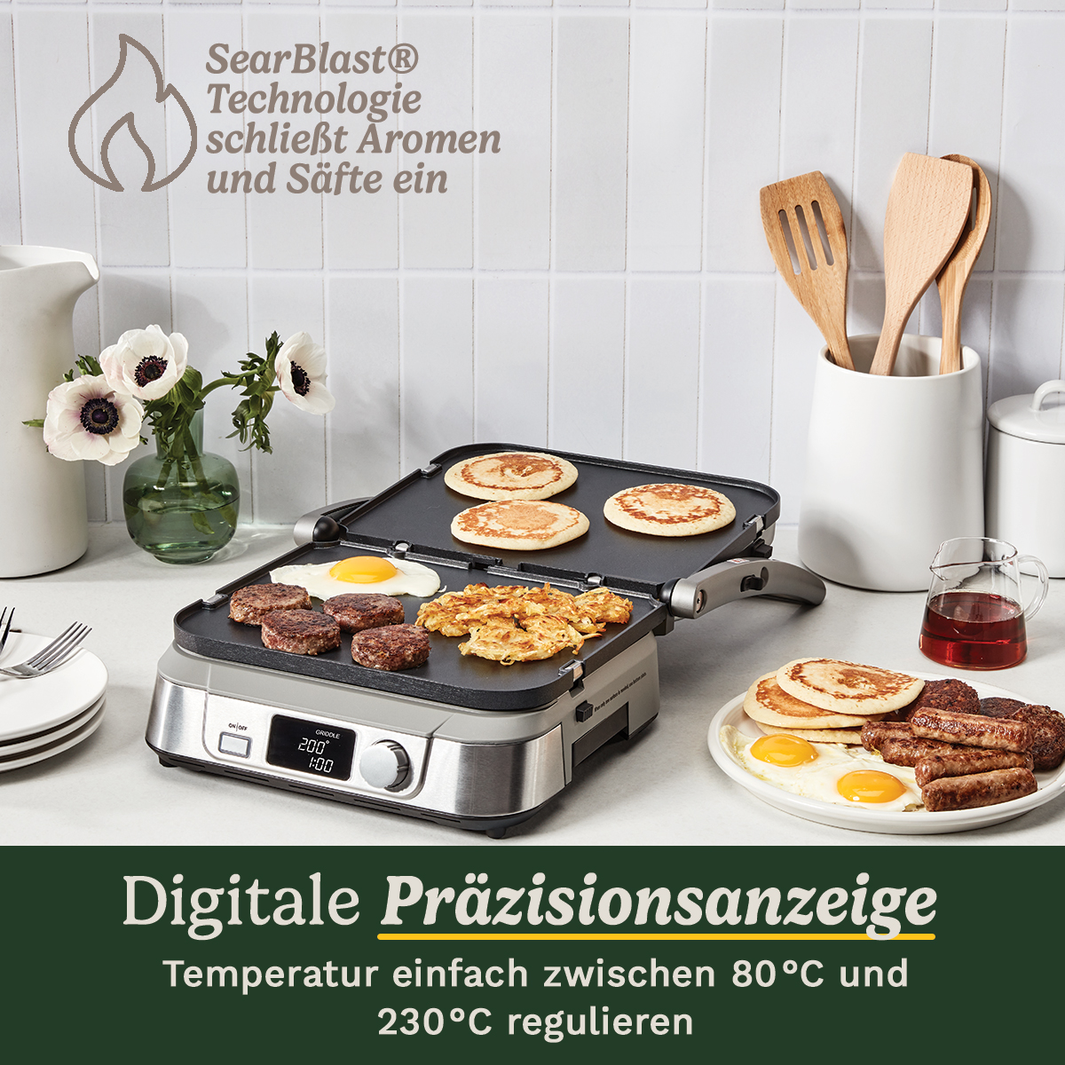 Una piastra elettrica con pancake, uova, salsicce e hash brown. Un vaso con fiori e utensili da cucina sullo sfondo.