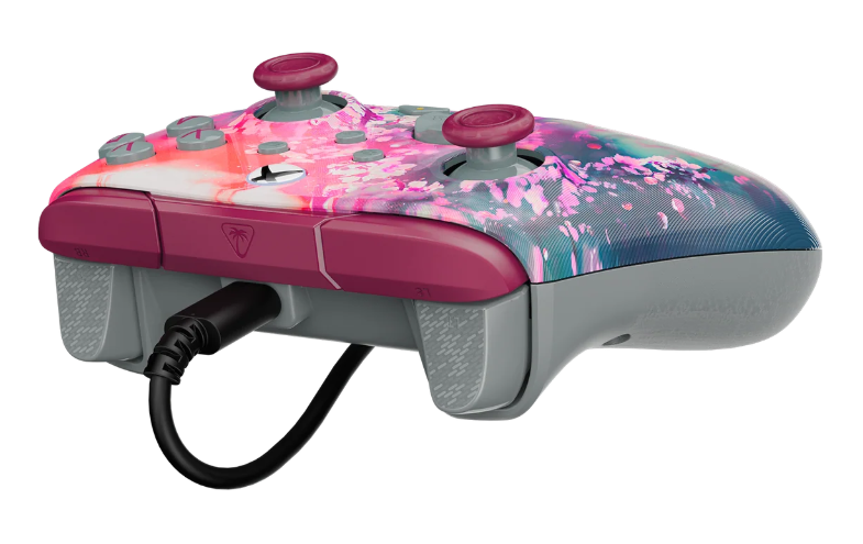 Pad do gier z kwiatowym wzorem, dwoma joystickami i przyciskami. Jest połączony czarnym kablem.