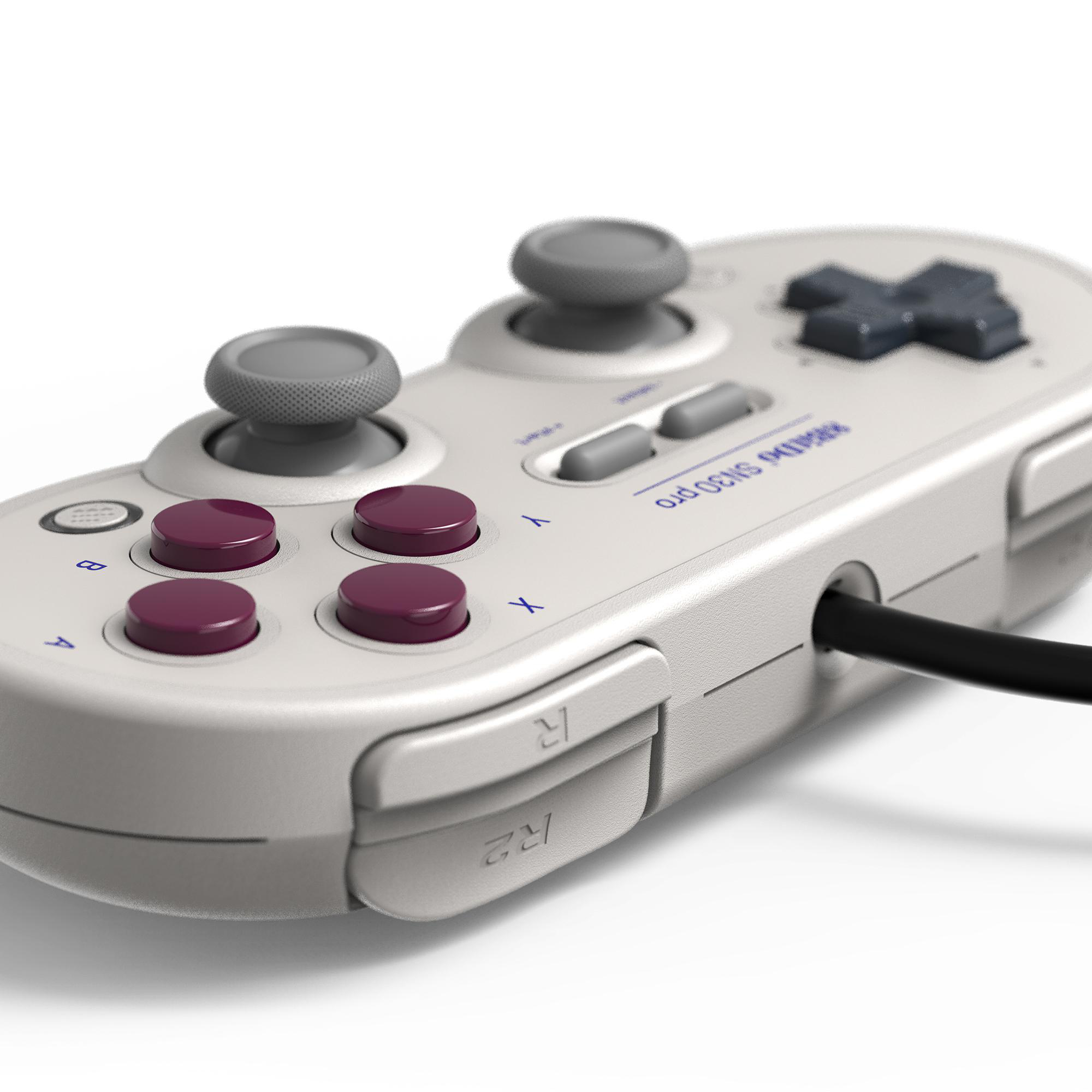 Nahaufnahme eines grauen SN30 Pro Controllers. Er hat lila Knöpfe, graue Joysticks und ein schwarzes Kabel.